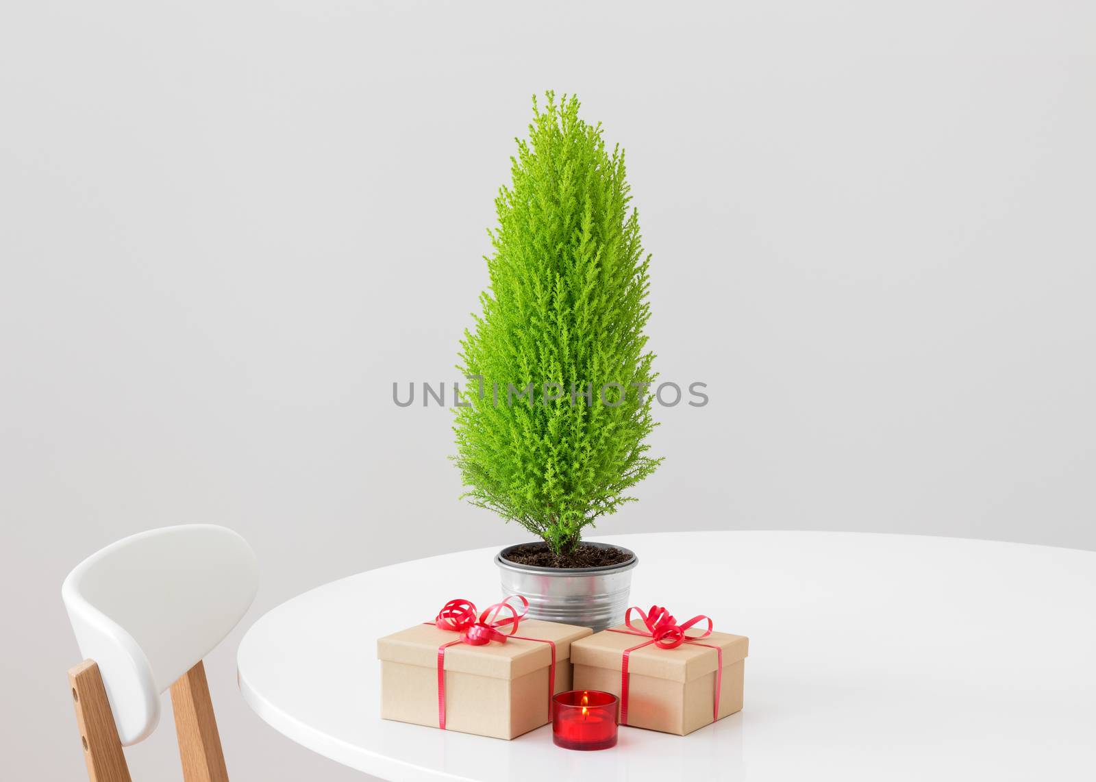 Little Christmas tree and gifts on a table by anikasalsera