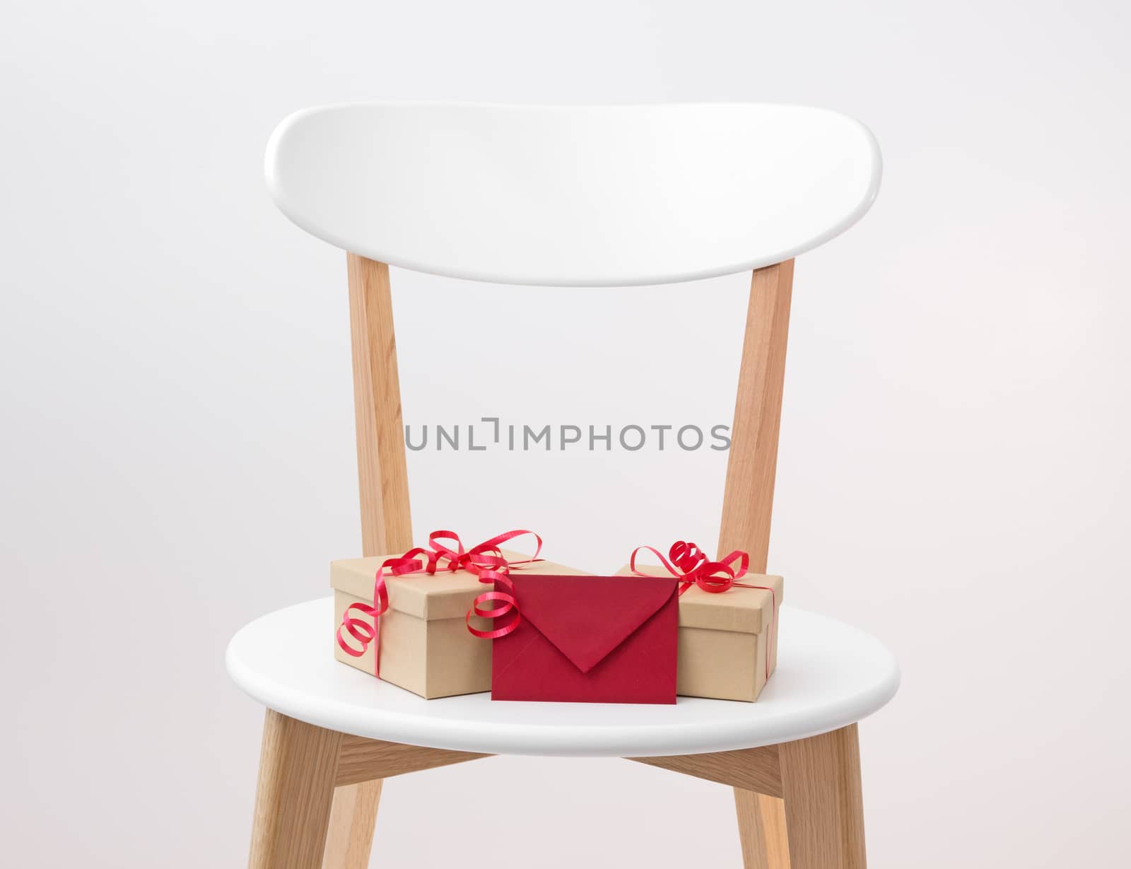 Gifts and red envelope on a wooden chair by anikasalsera