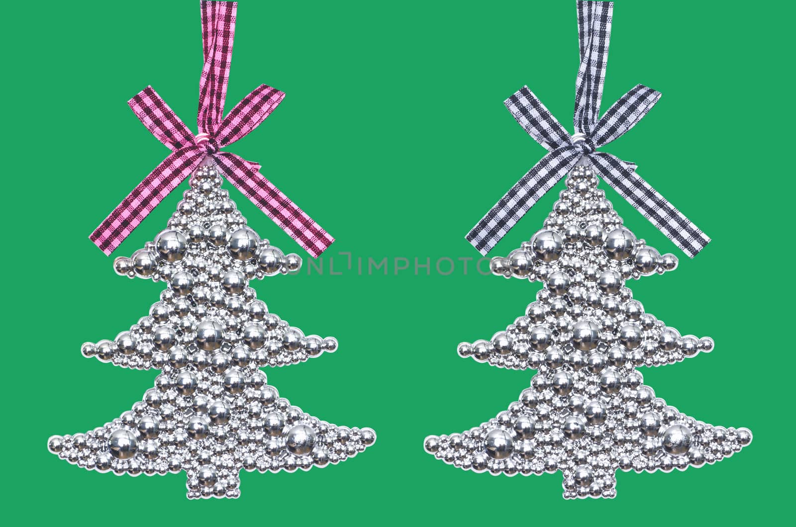 Two silver Christmas tree - decoration isolated on green  background