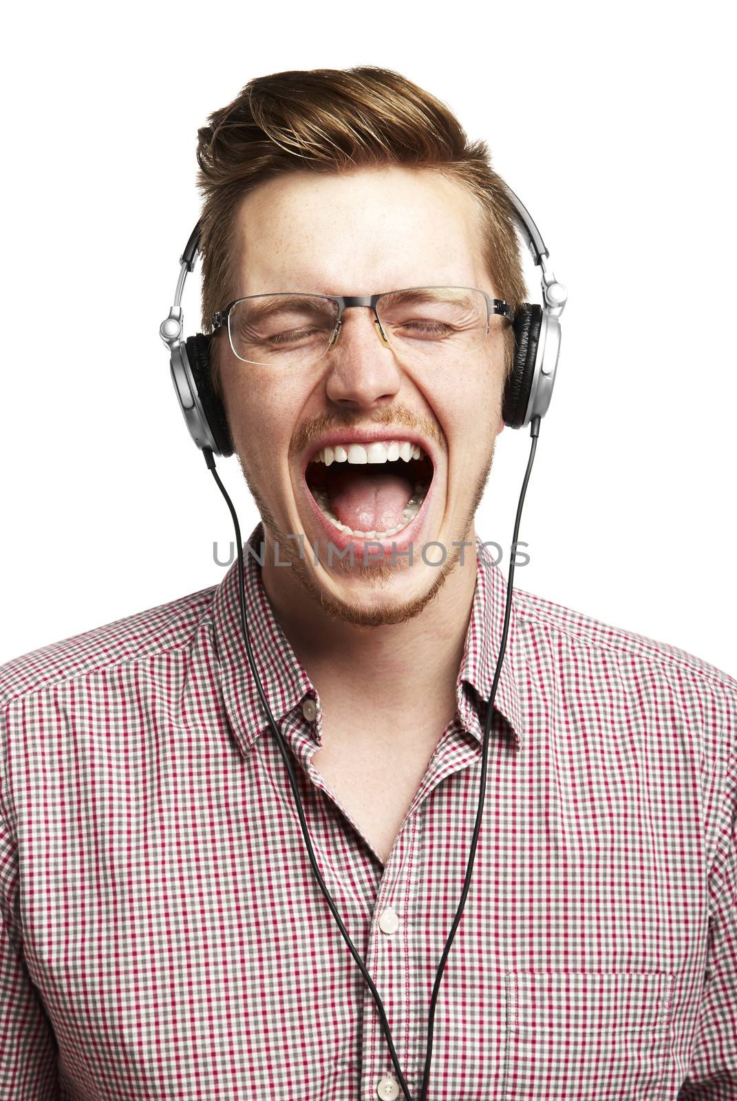 Young man listening to music and singing with headphones. Isolated on white. 