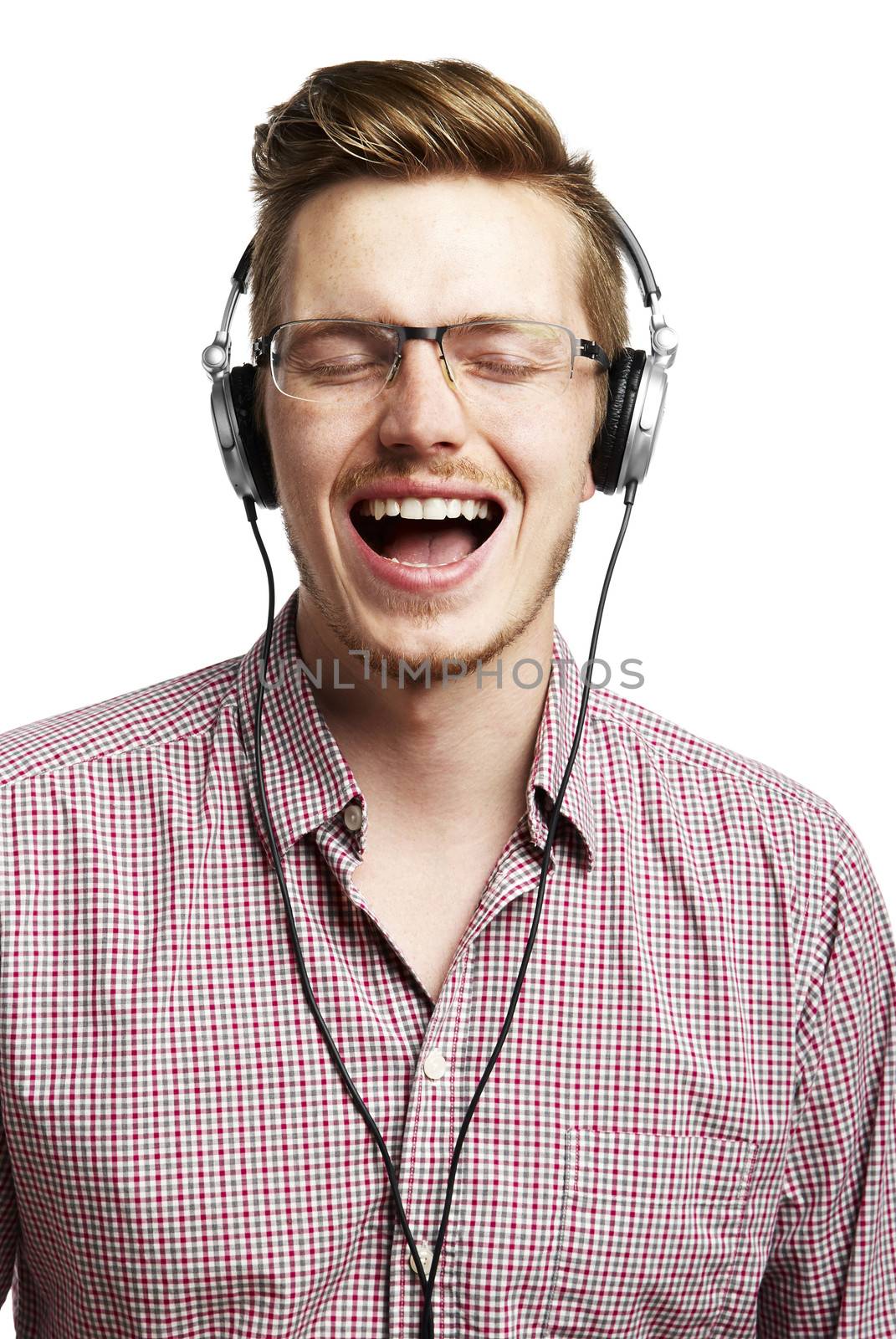 Young man listening to music and singing with headphones. Eyes Closed. 