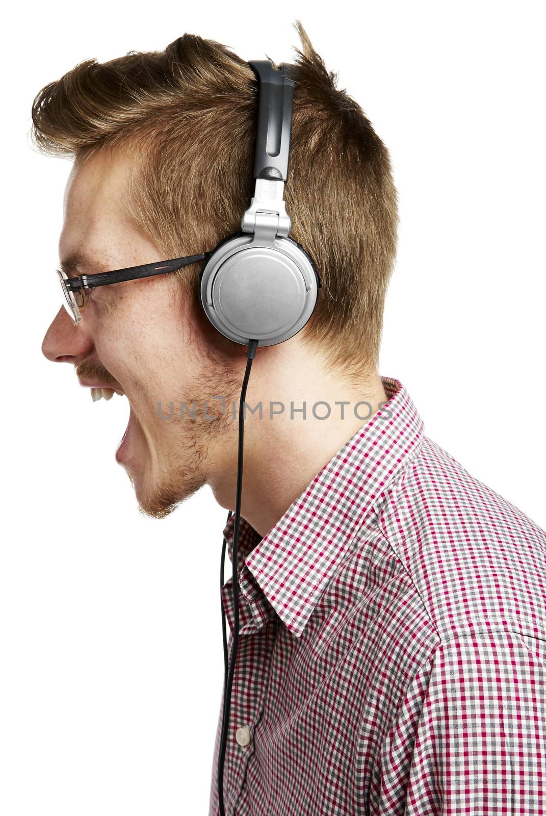 Young man listening to music and singing with headphones. Isolated on white. 