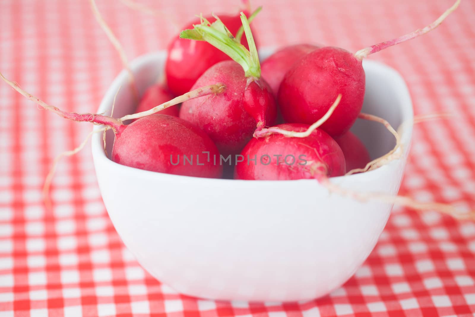 radish in bowl on checkered fabric