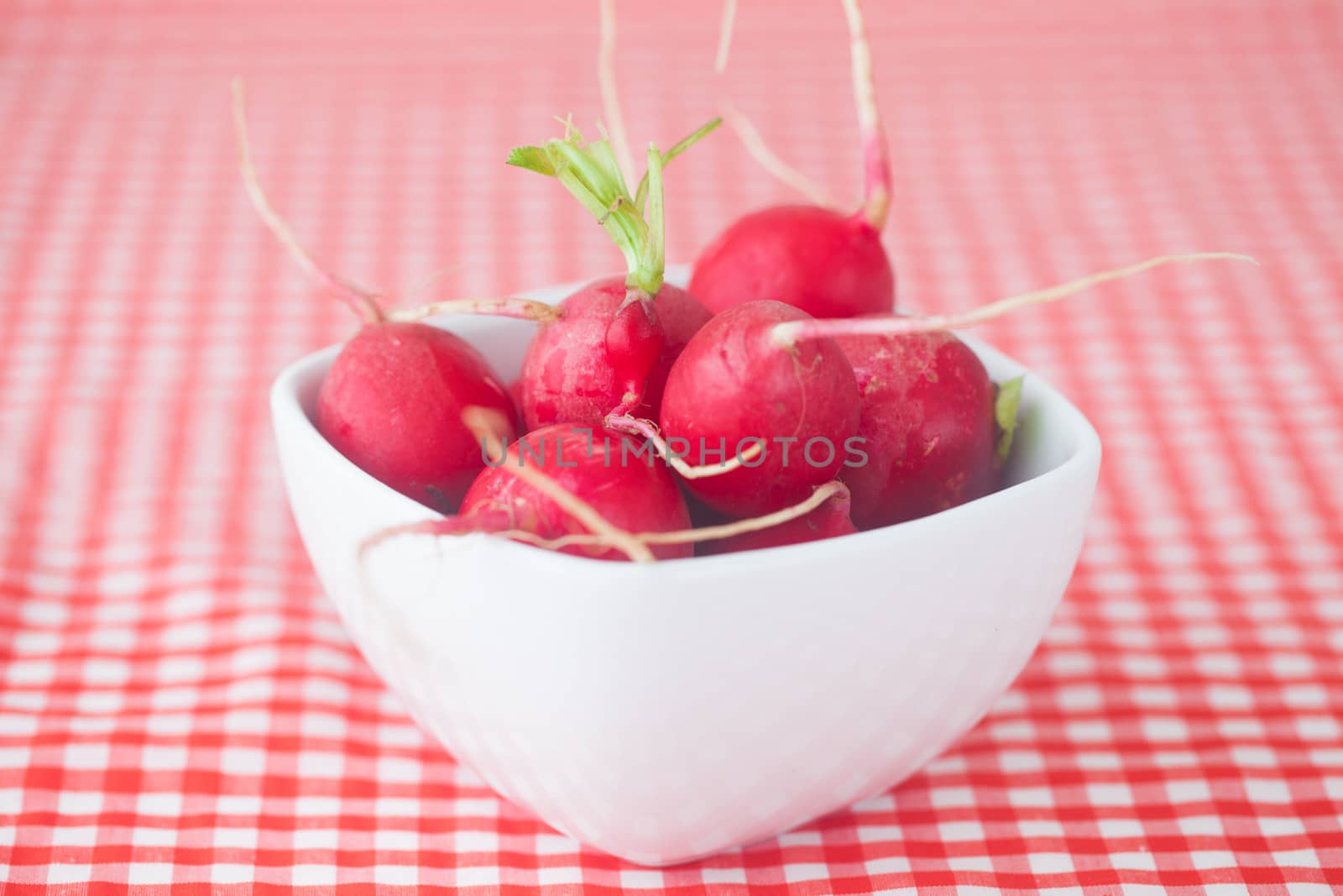 radish in bowl on checkered fabric