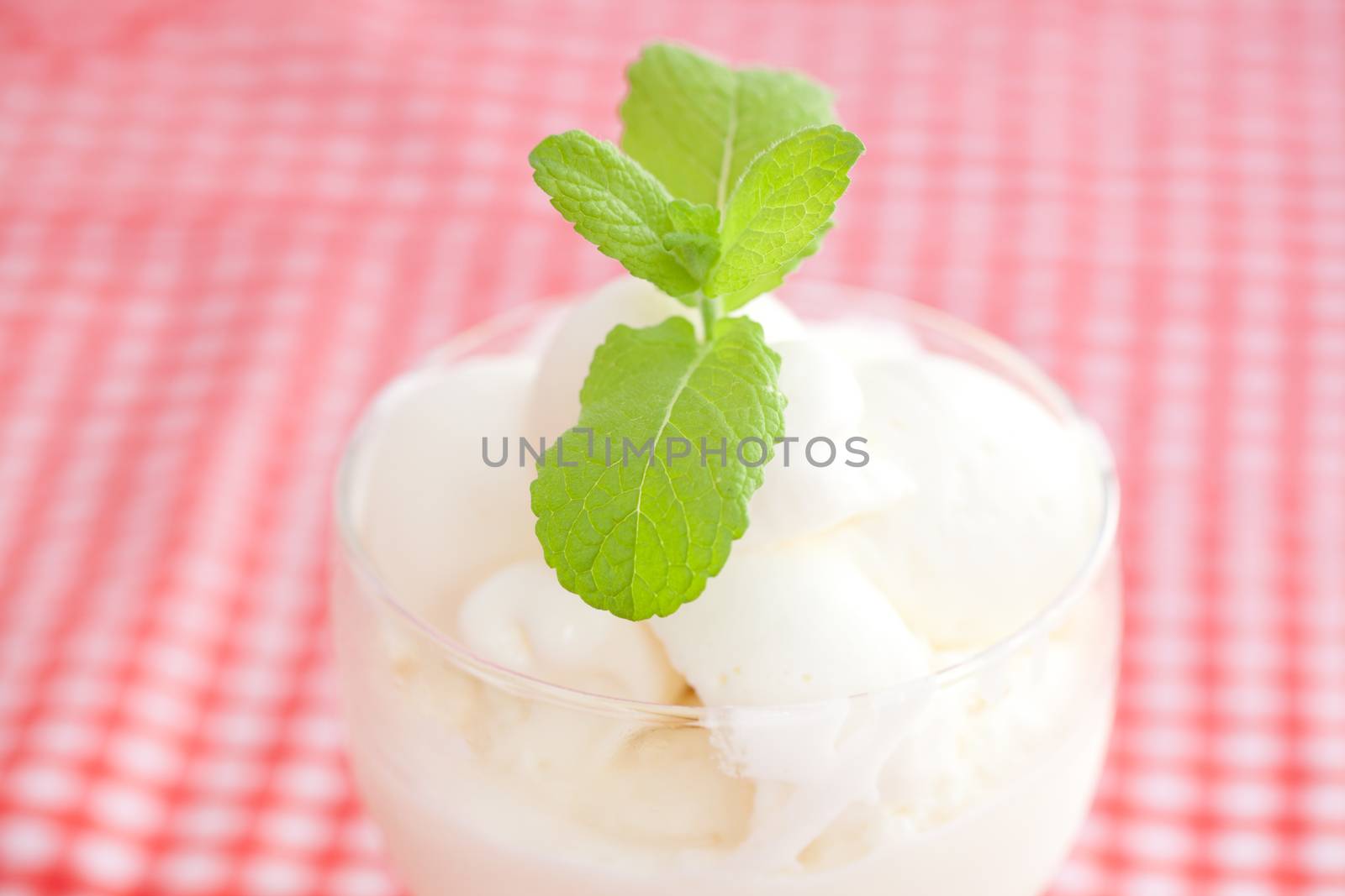 ice cream with mint in a glass bowl on plaid fabric