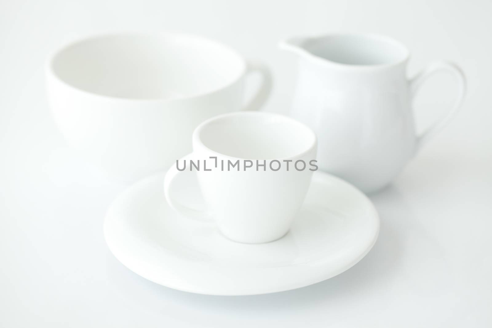 white cup with saucer and milk jug 