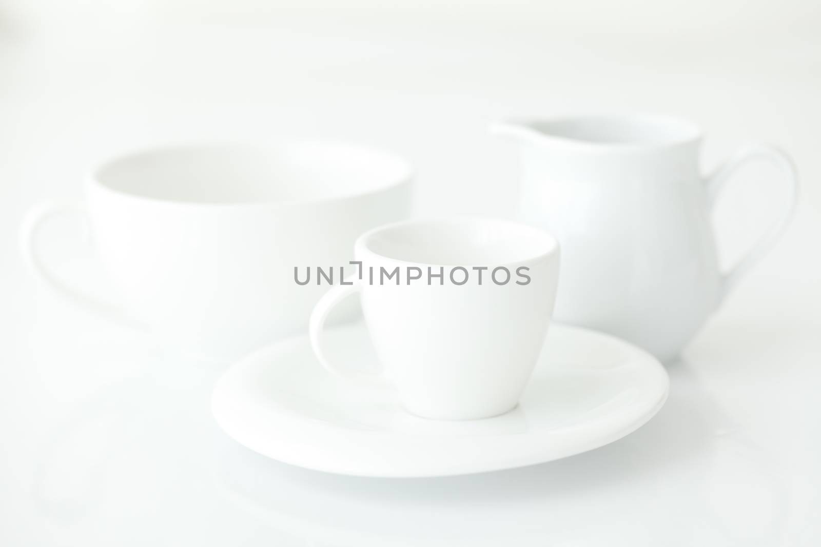 white cup with saucer and milk jug 