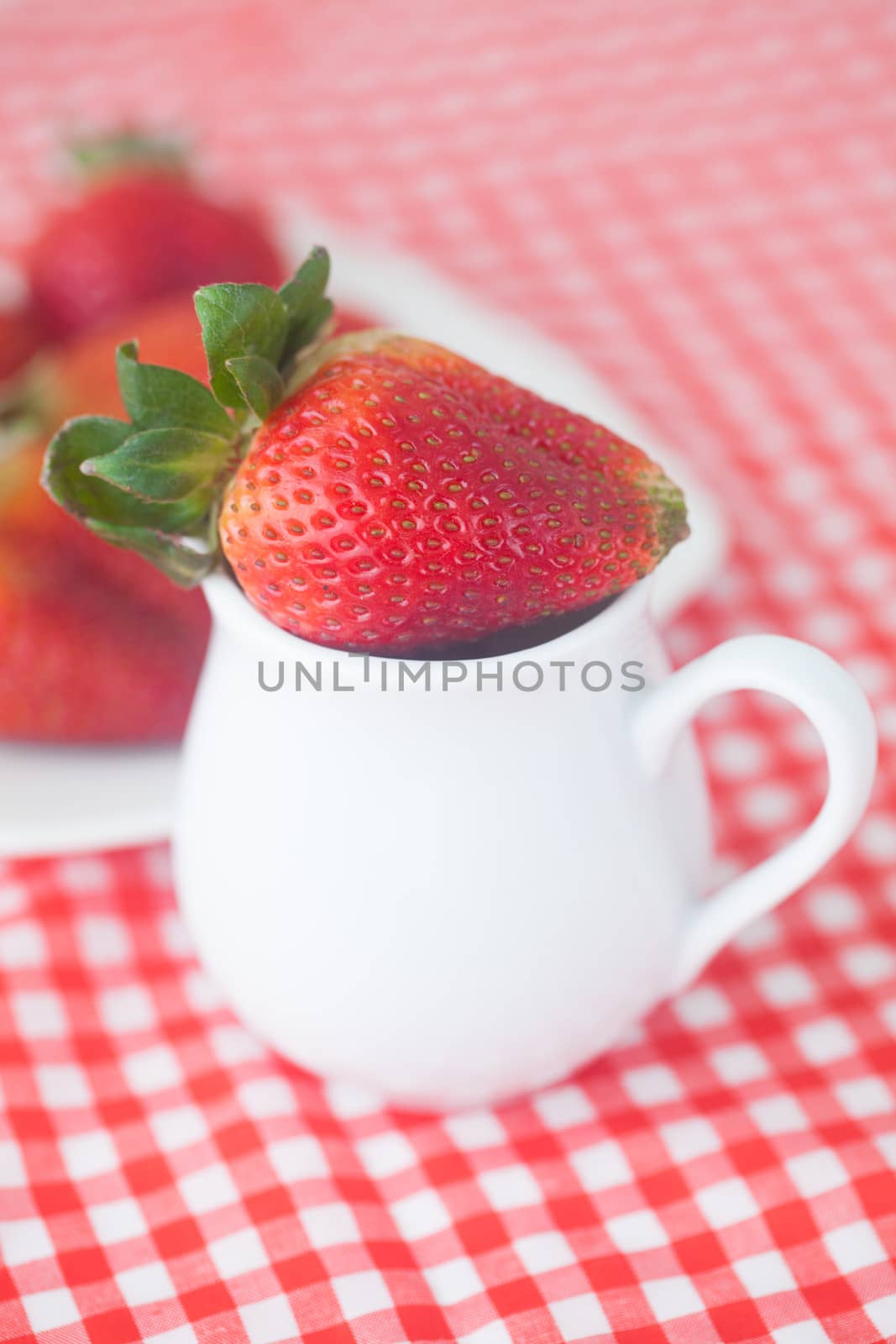 strawberries in jar on checkered fabric