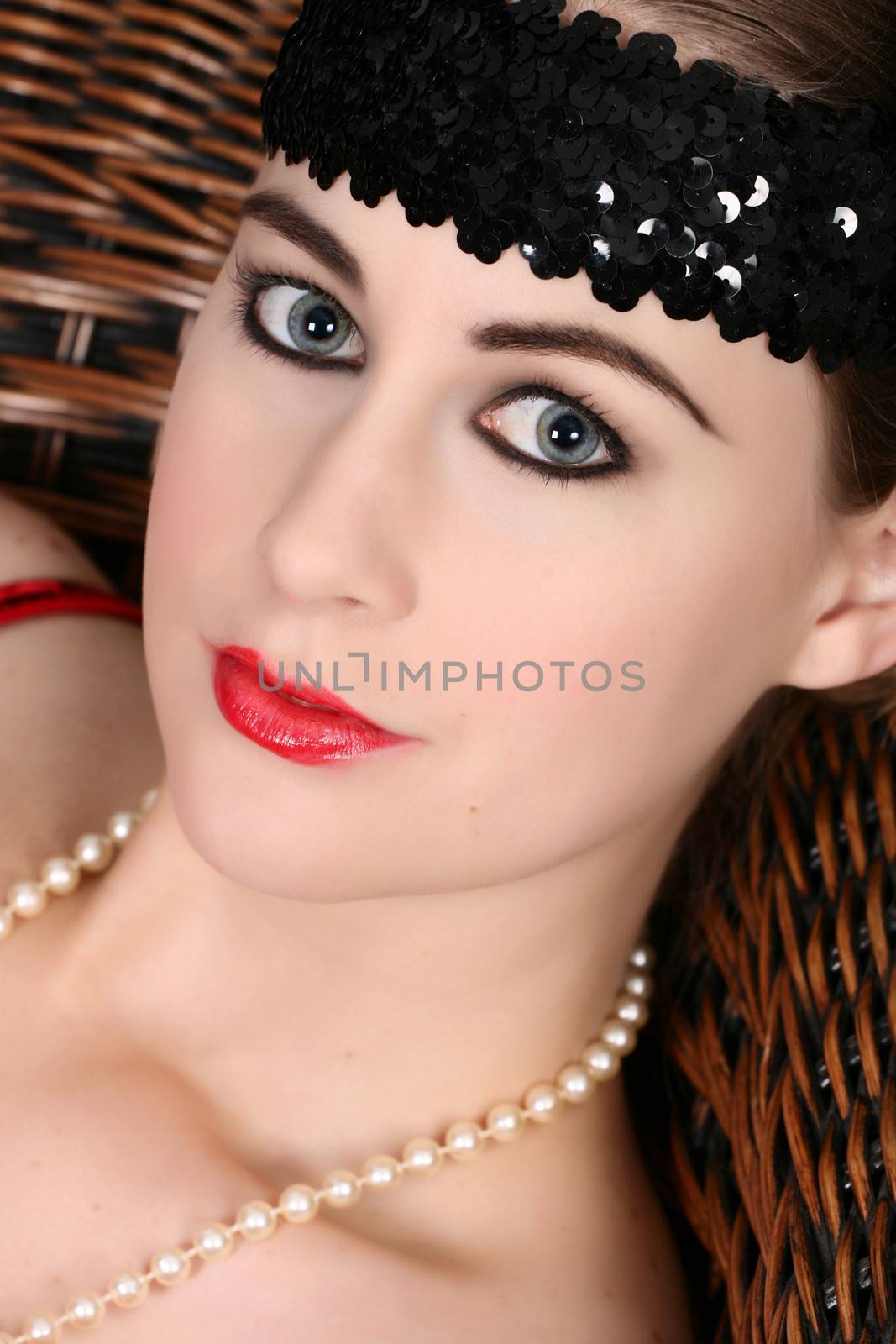 Classical blone female model with black headband and pearls