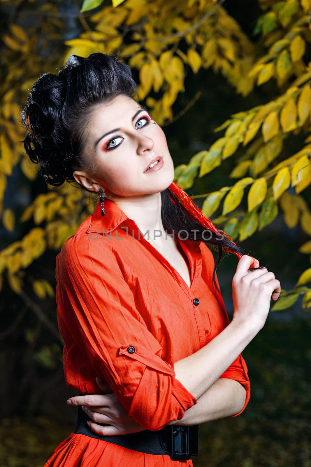 Young attractive girl in red shirt and with makeup close-up portrait in autumn park