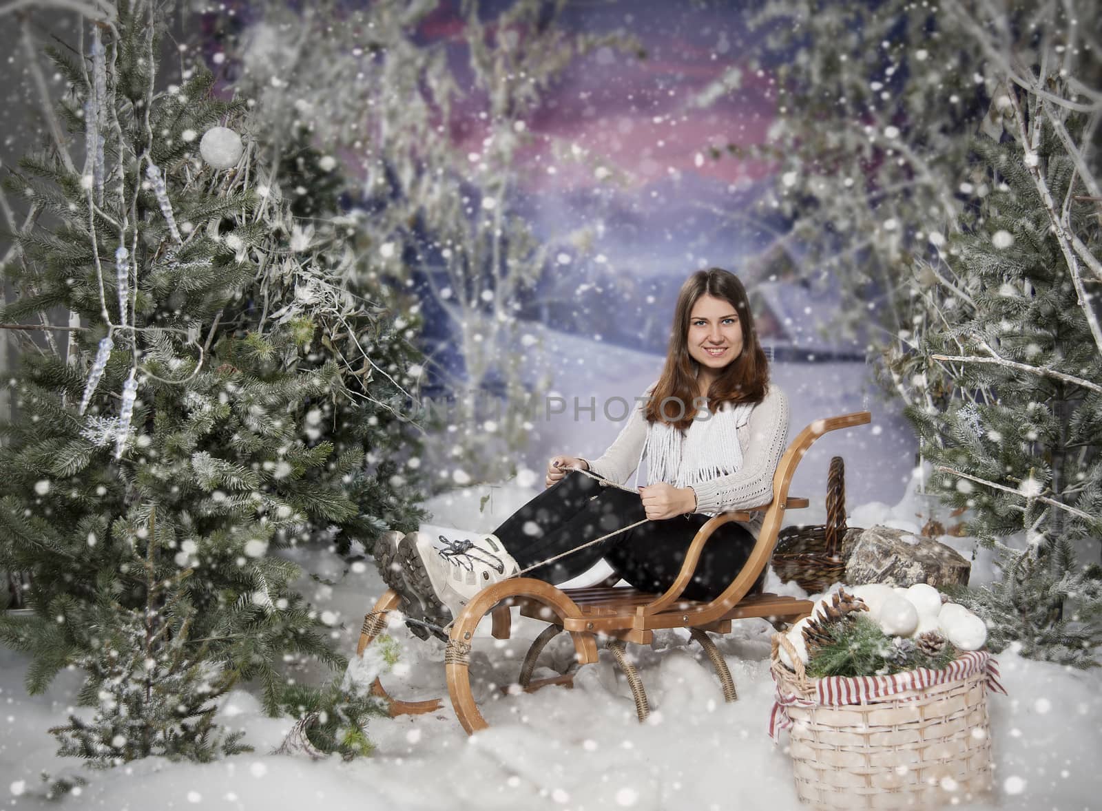 cheerful girl in winter forest on a sledge