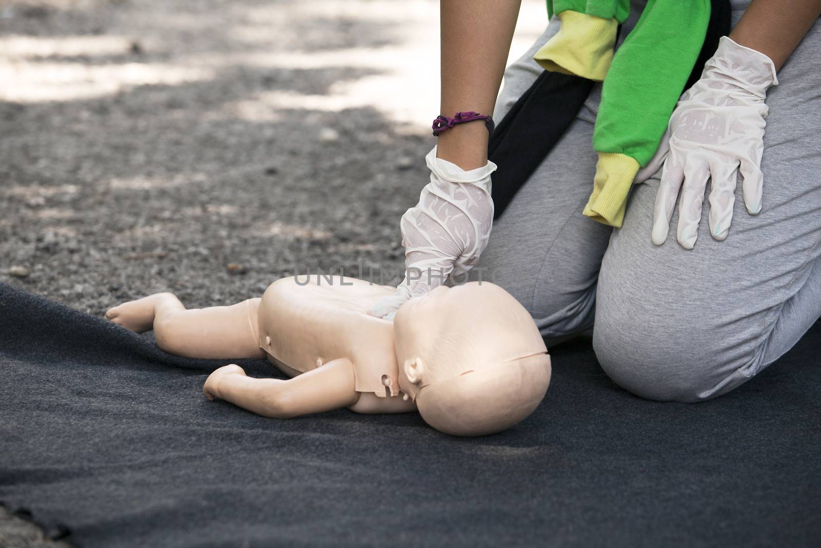 Paramedic demonstrates CPR on infant dummy