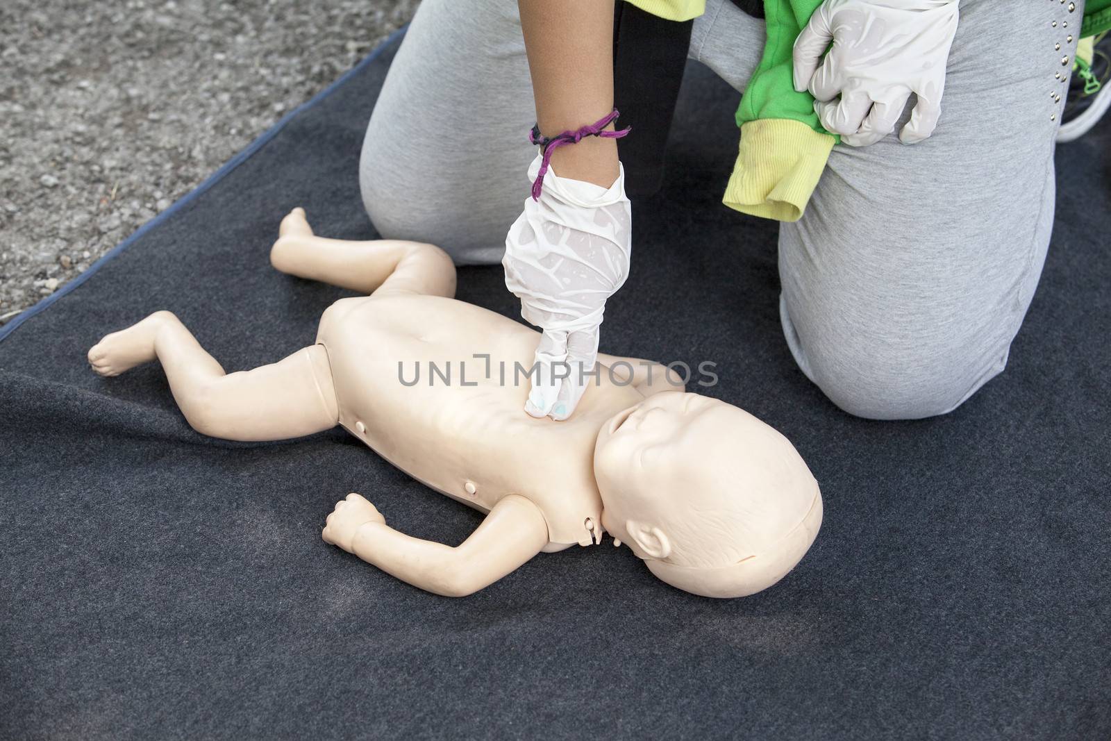 Paramedic demonstrates CPR on infant dummy