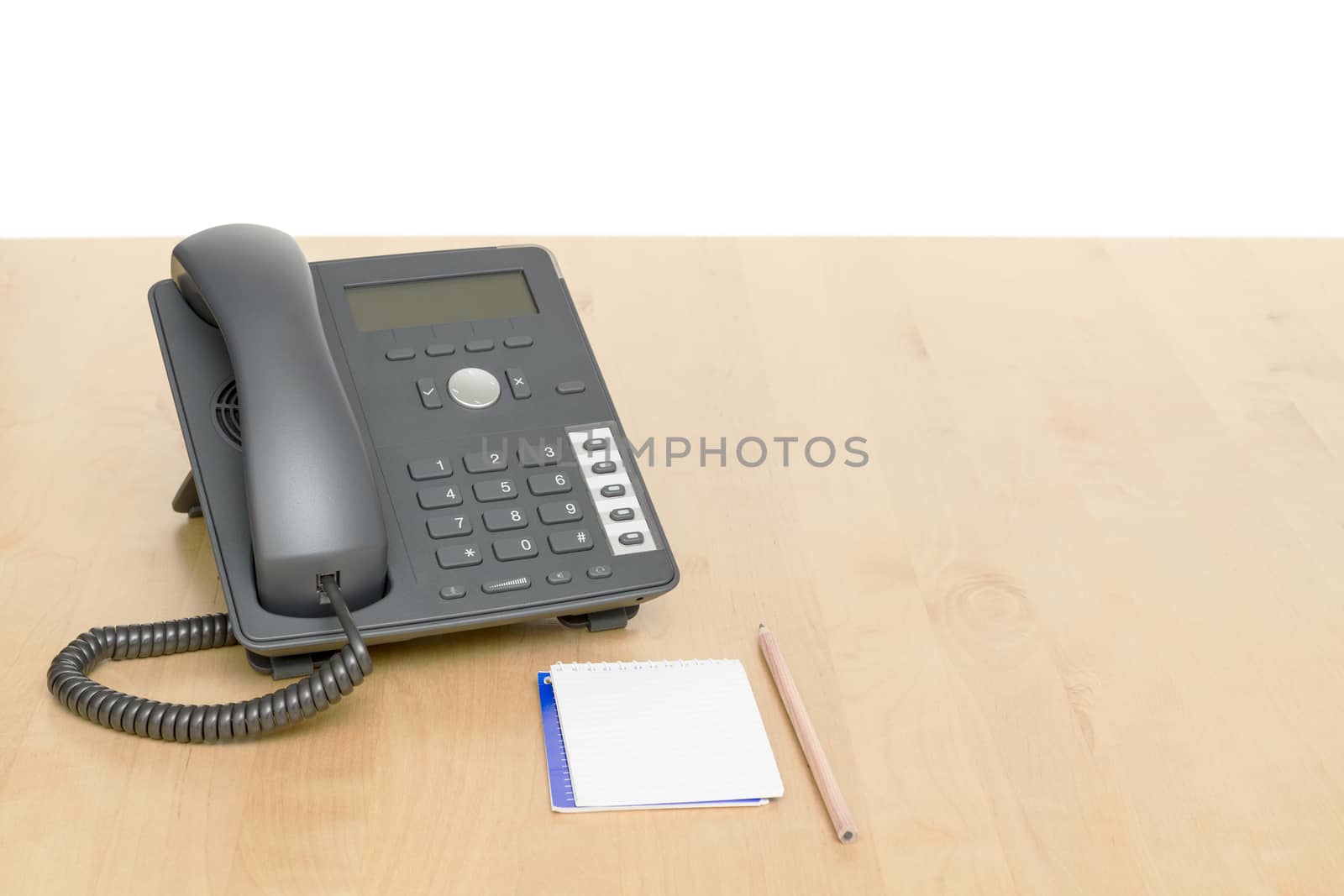 phone on desk with notepad on wooden desk by gewoldi