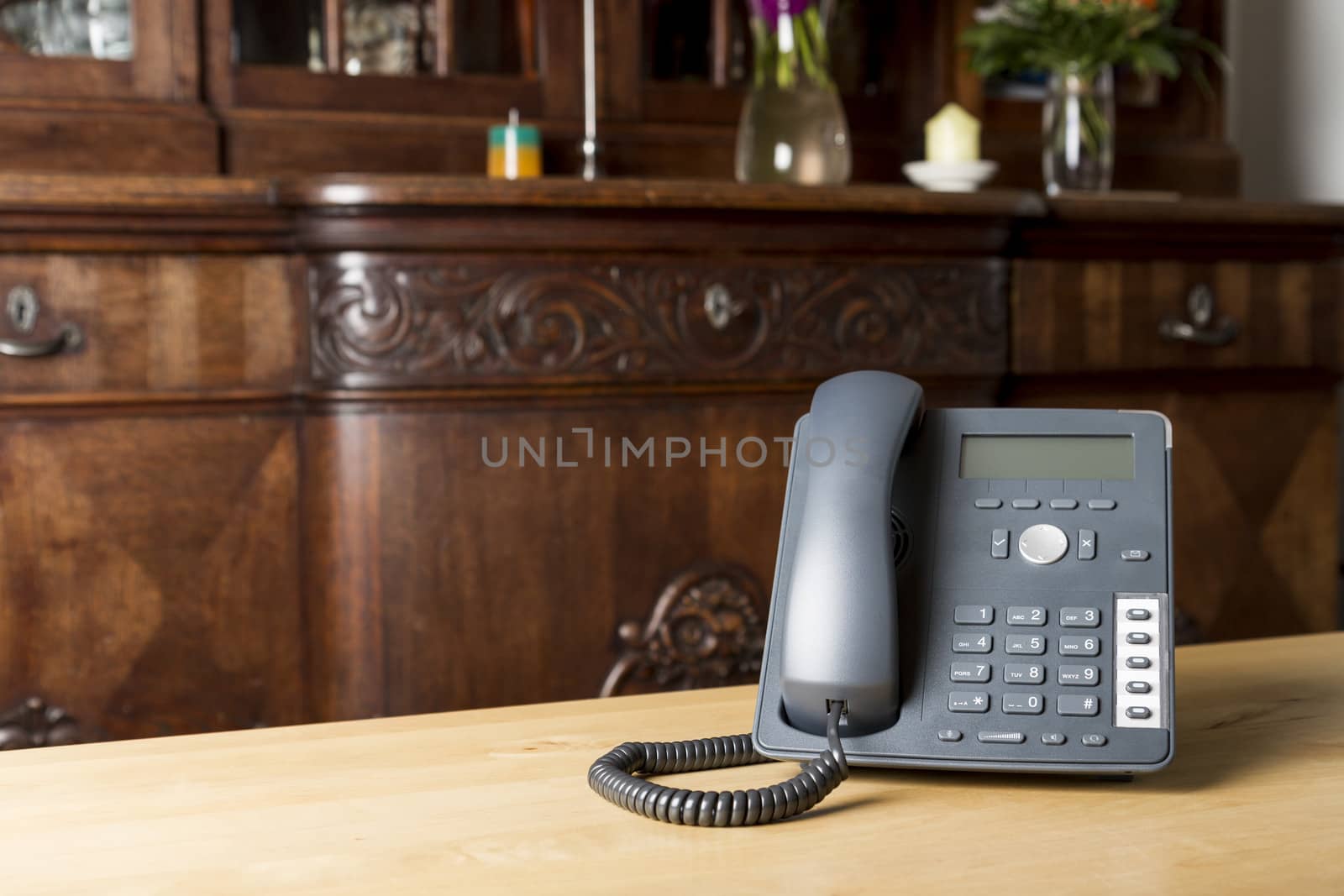 modern phone on wooden table in living room with old commode