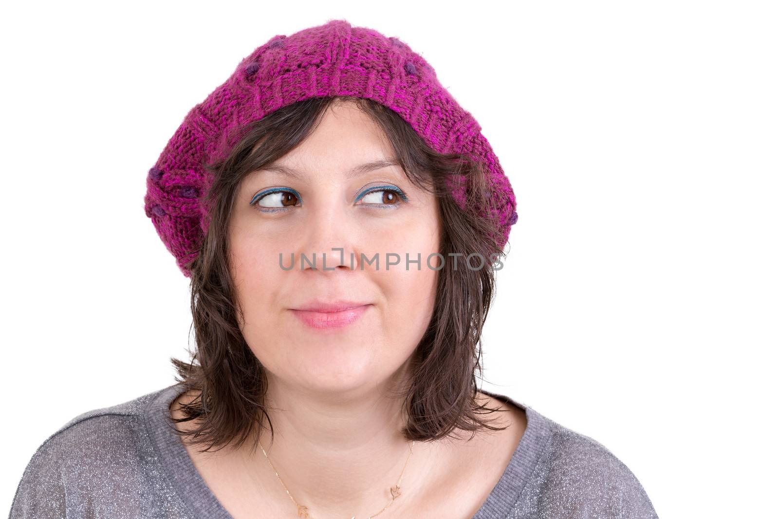 Thoughtful woman wearing a knitted purple winter cap smiling in anticipation of being able to realise her dreams, looking off with her eyes to the side and smiling, isolated on white