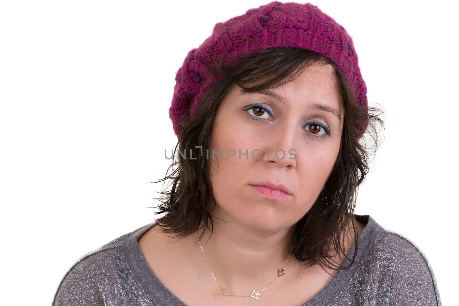 Woman wearing a purple beanie looking at the camera with a mournful woebegone expression and dull eyes, isolated on white
