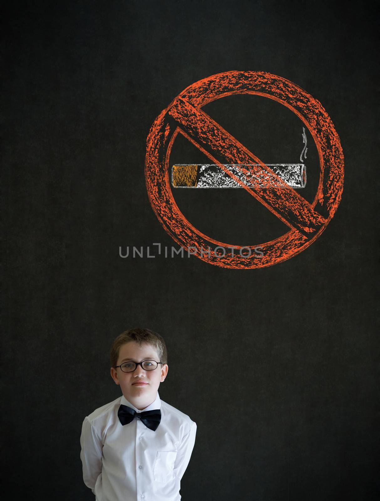 Thinking boy dressed up as business man with no smoking chalk sign on blackboard background