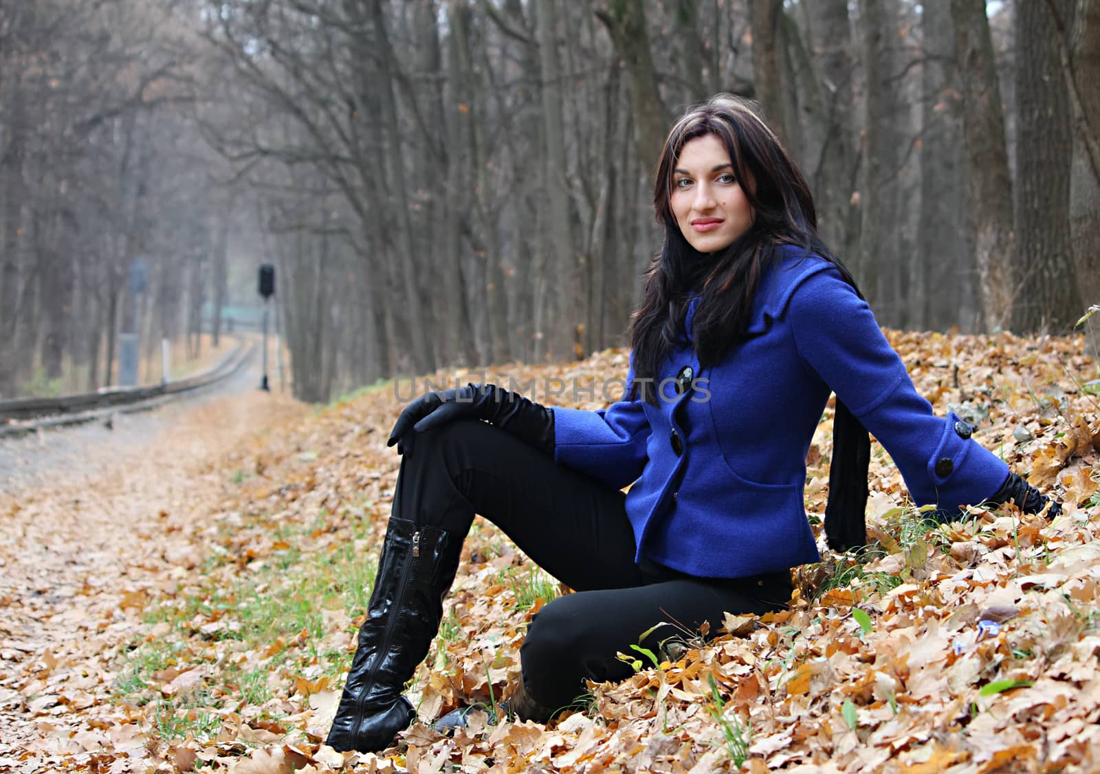 Young woman sitting in the autumn park