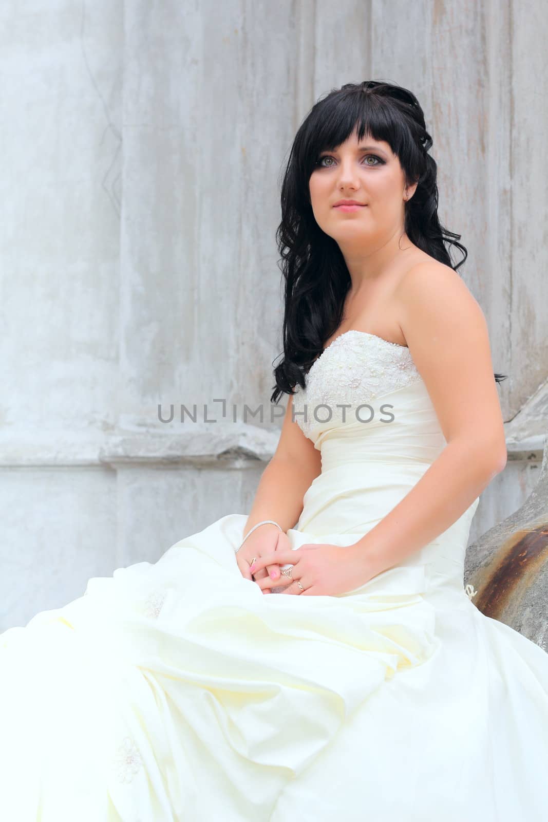 Girl in the wedding dress sitting at a stones