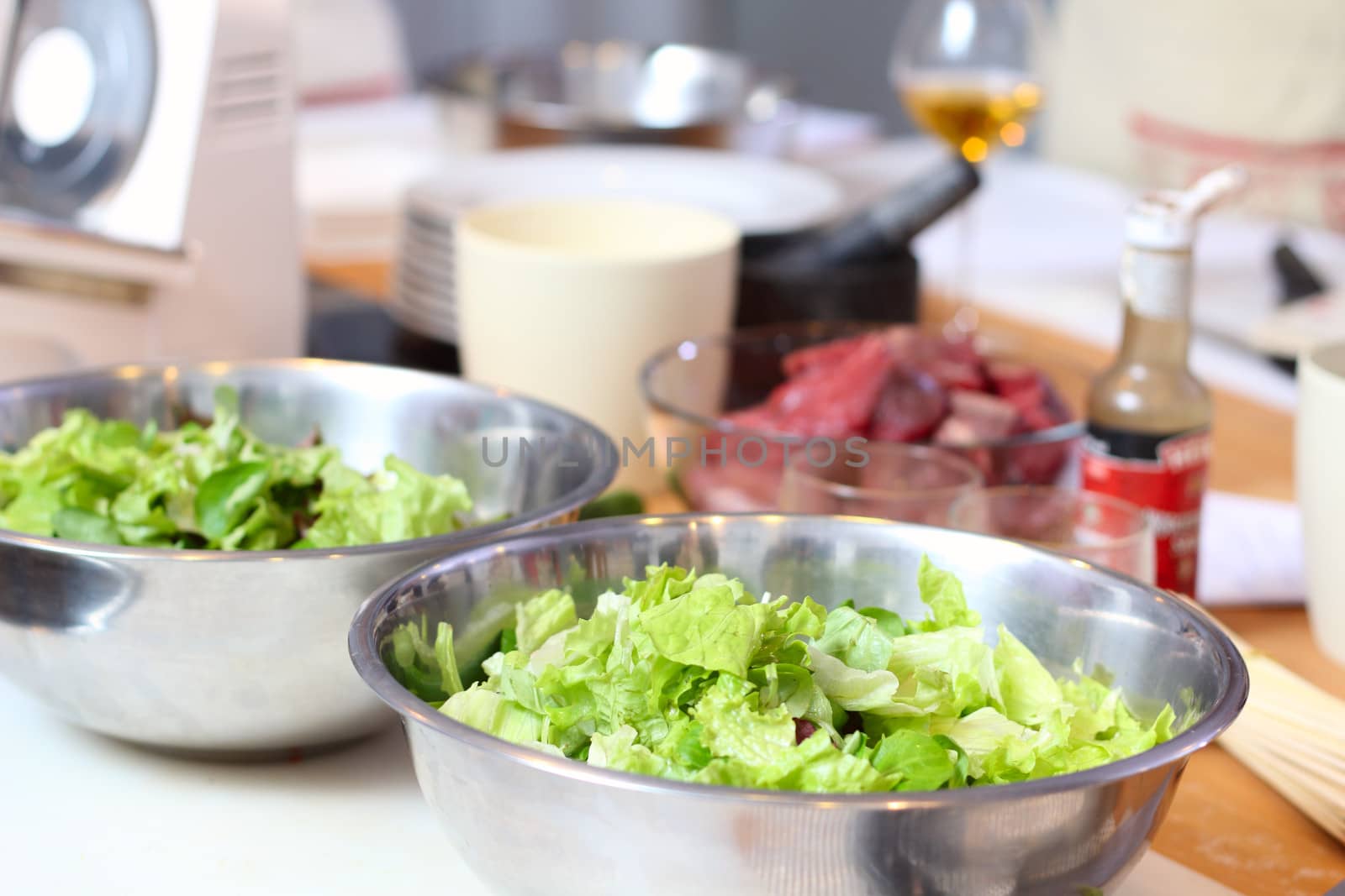 Green salad leaves are on a kitchen by dedmorozz