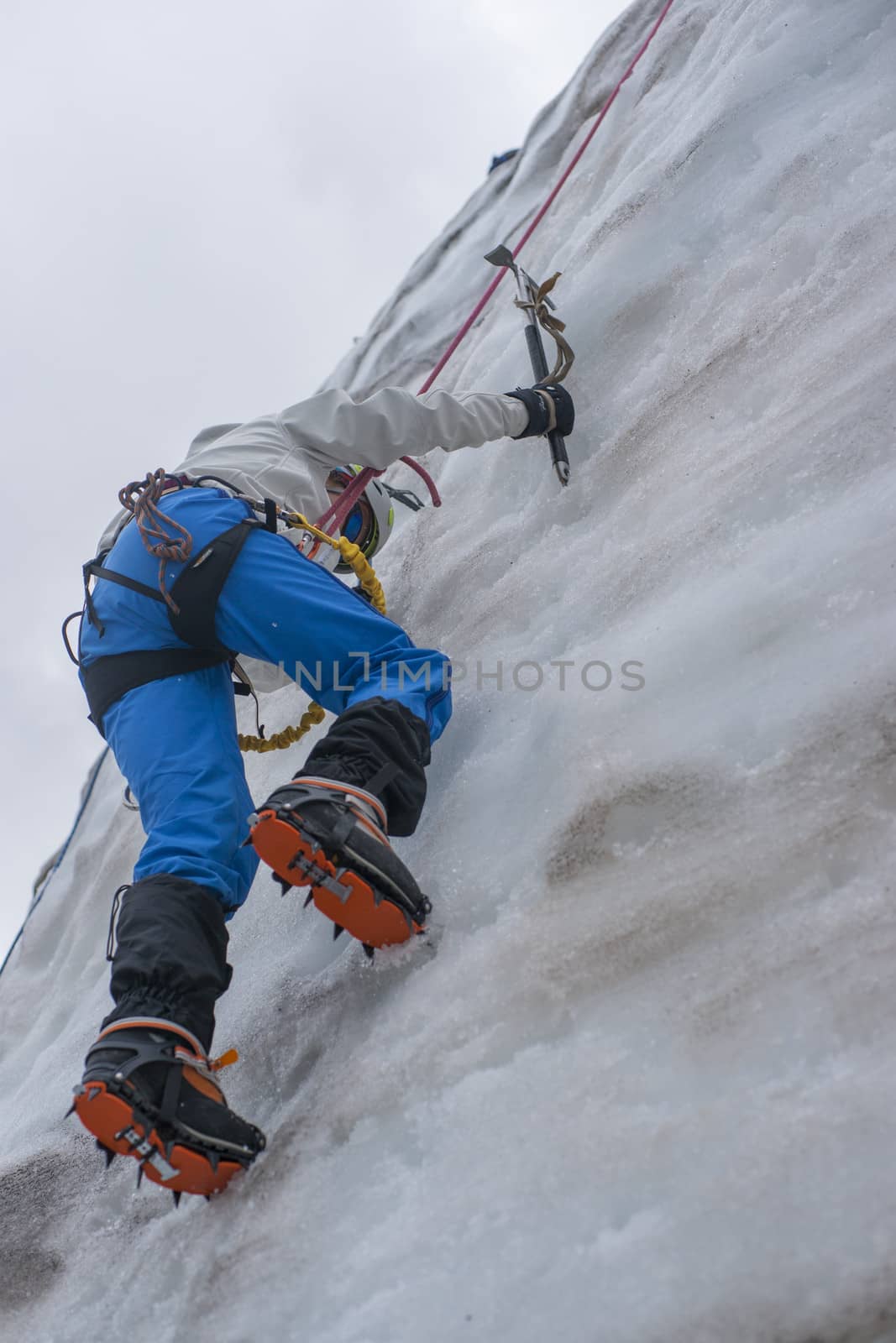 Girl climb up on the ice at glacier