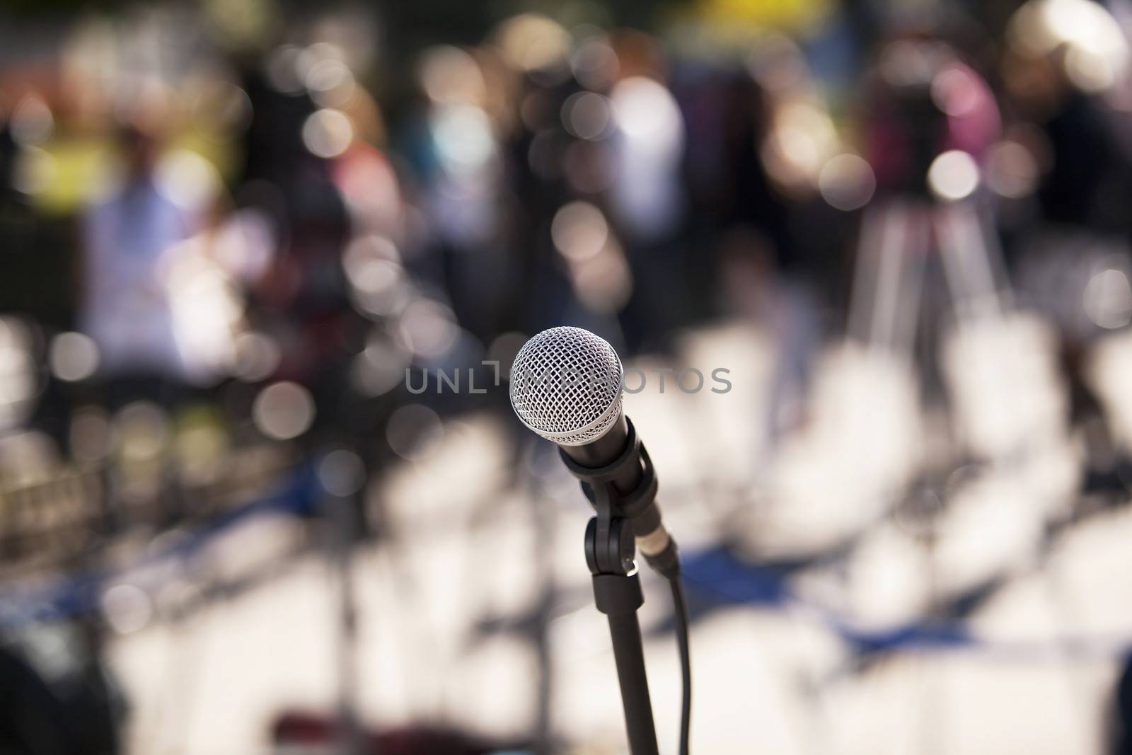 Microphone in focus against blurred audience