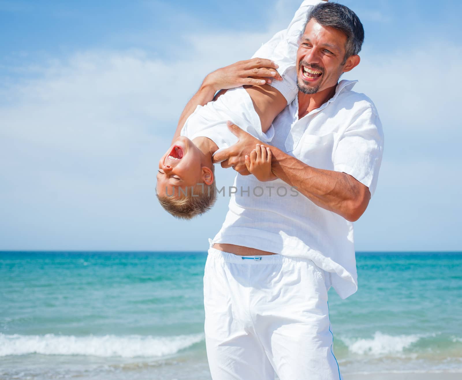 Father and son having fun on tropical beach