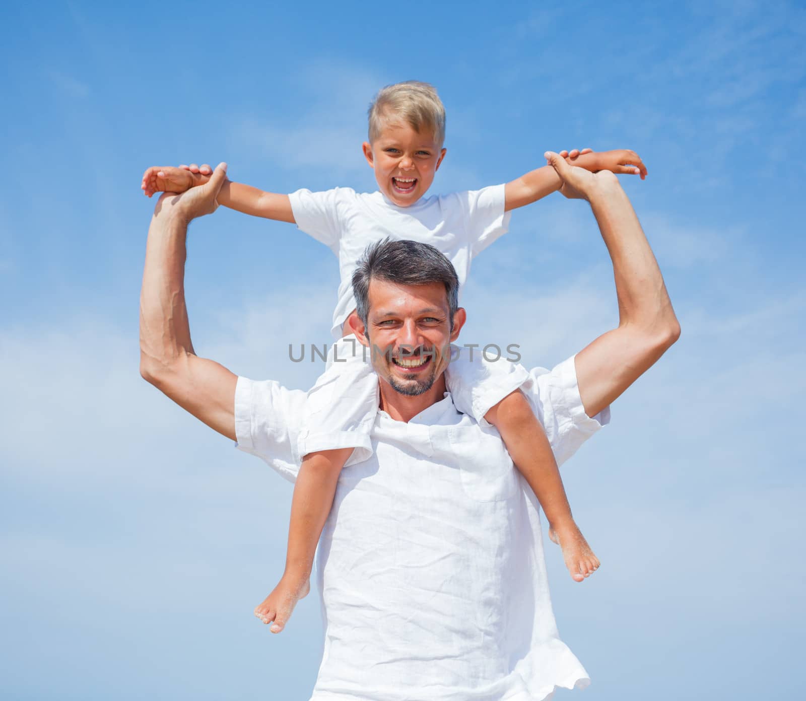 Father and son having fun on tropical beach