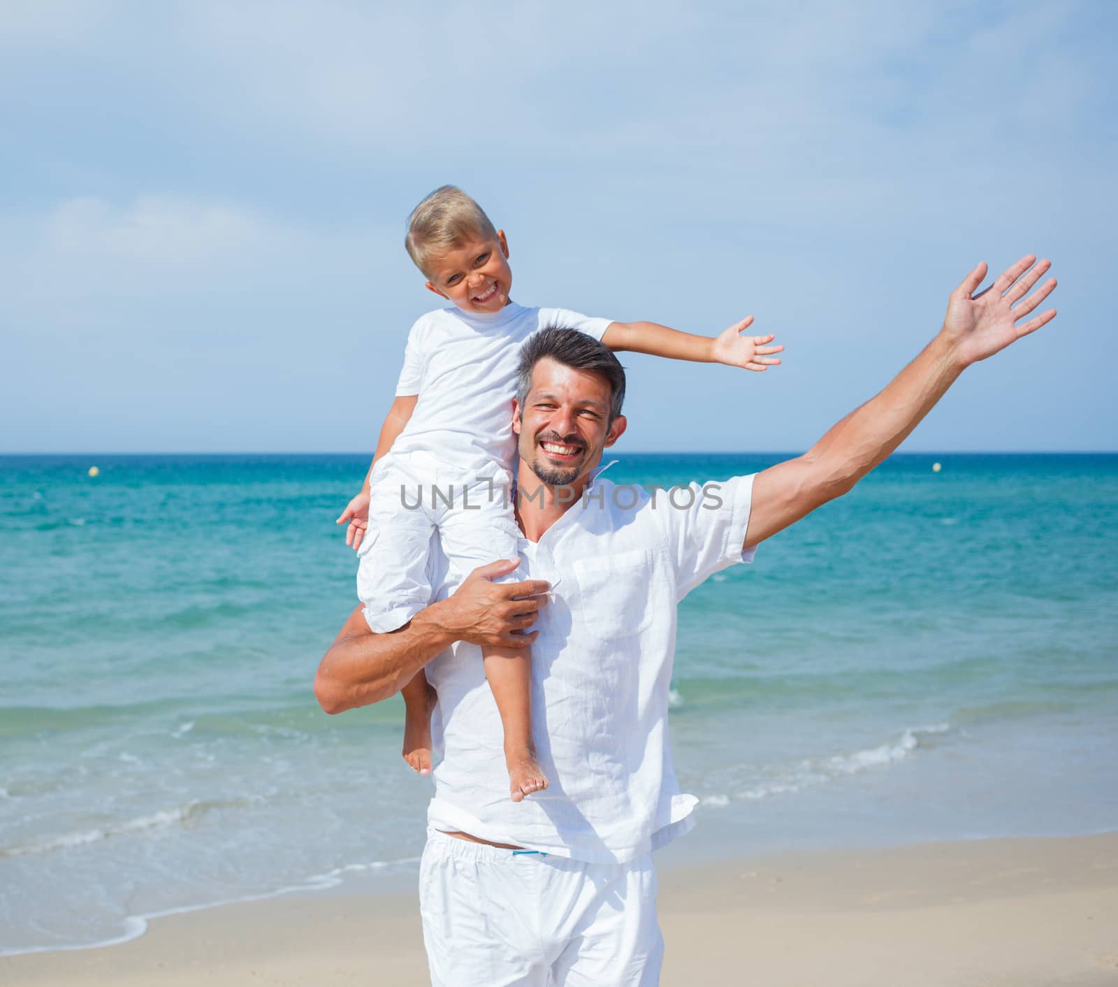 Father and son having fun on tropical beach