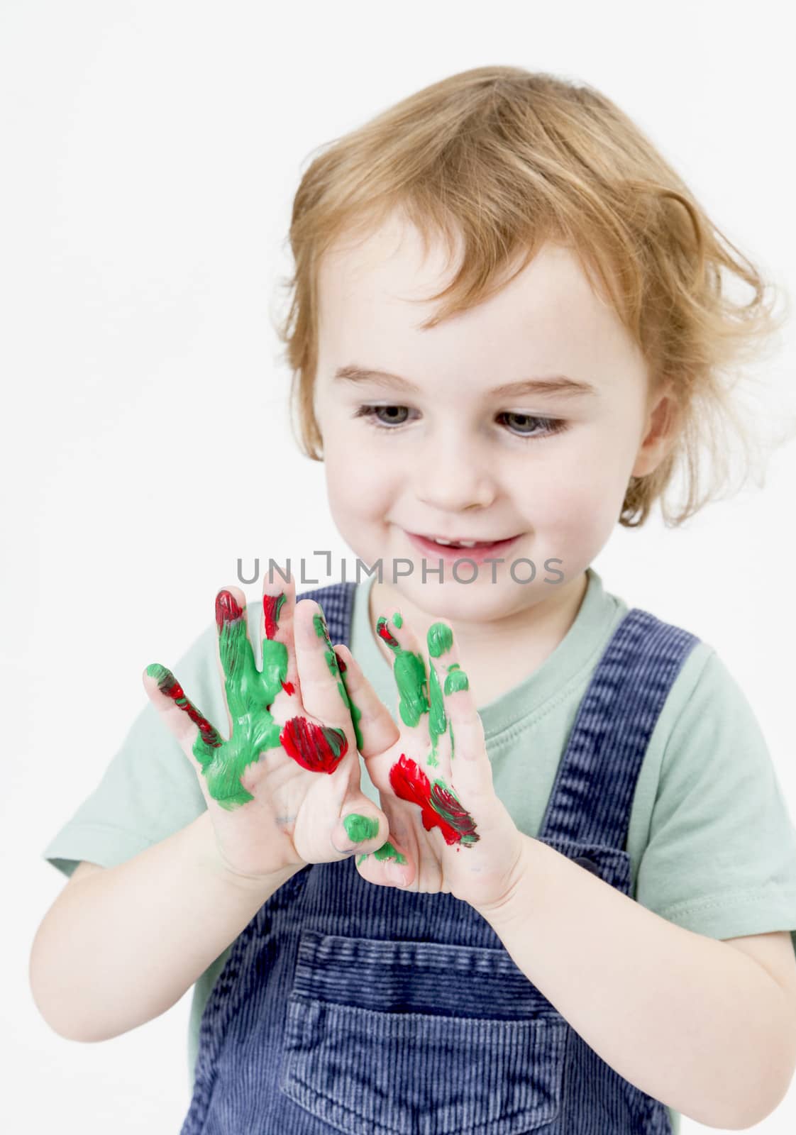 cute little girl with finger paint. vertical image in light grey background