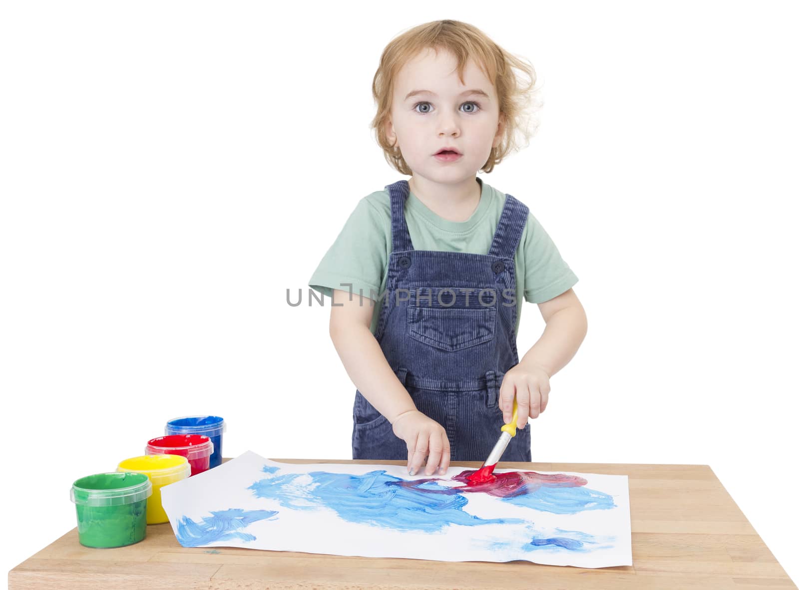 cute girl painting on small desk in white background. studio shot