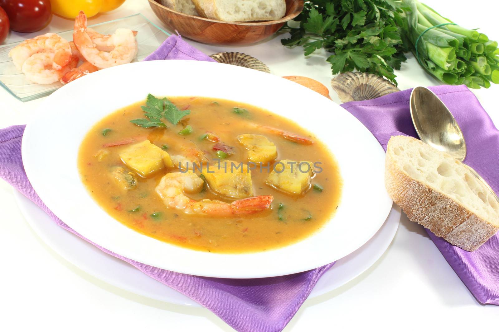 healthy bouillabaisse with seafood and parsley on a light background