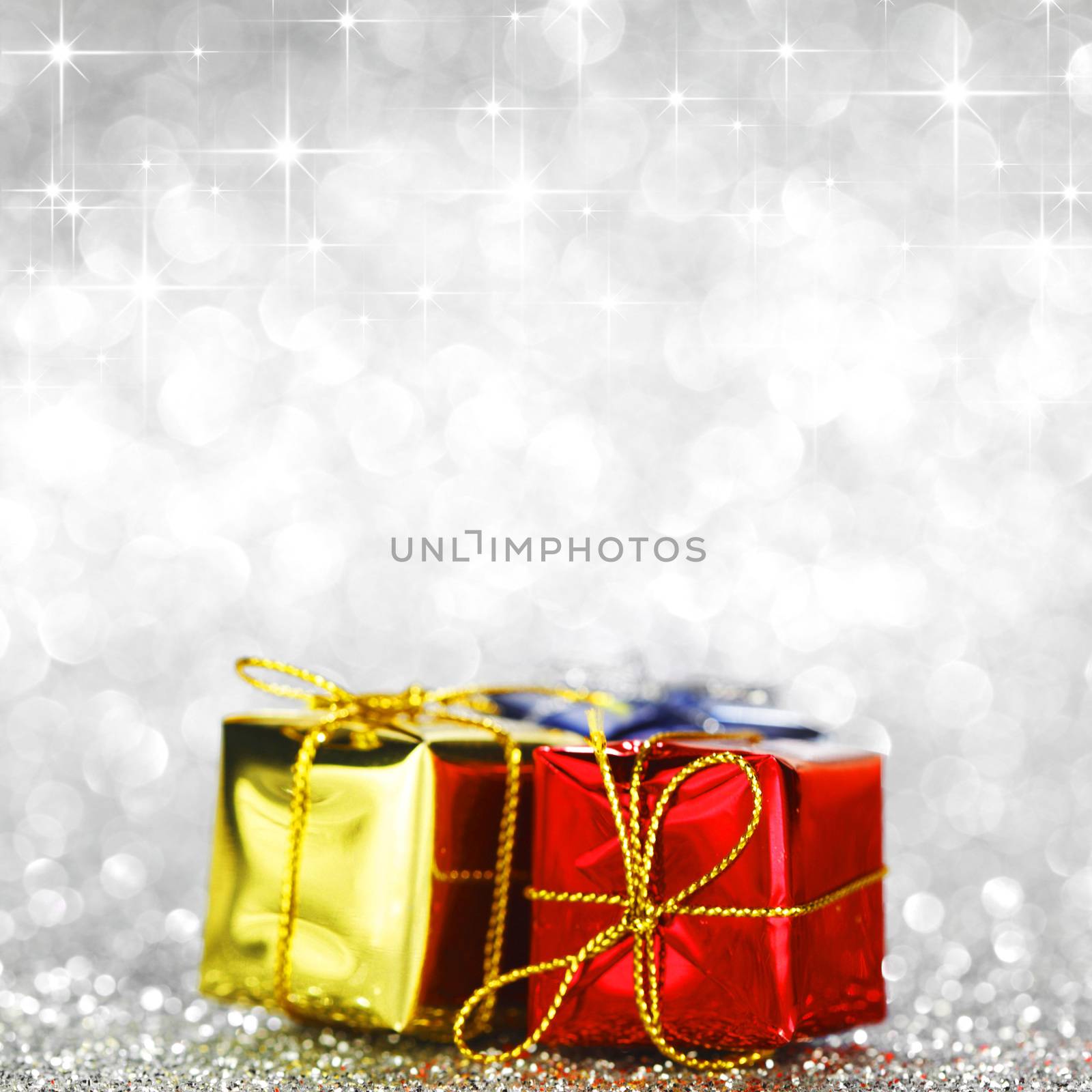 Holiday gifts over shiny glitter background with stars