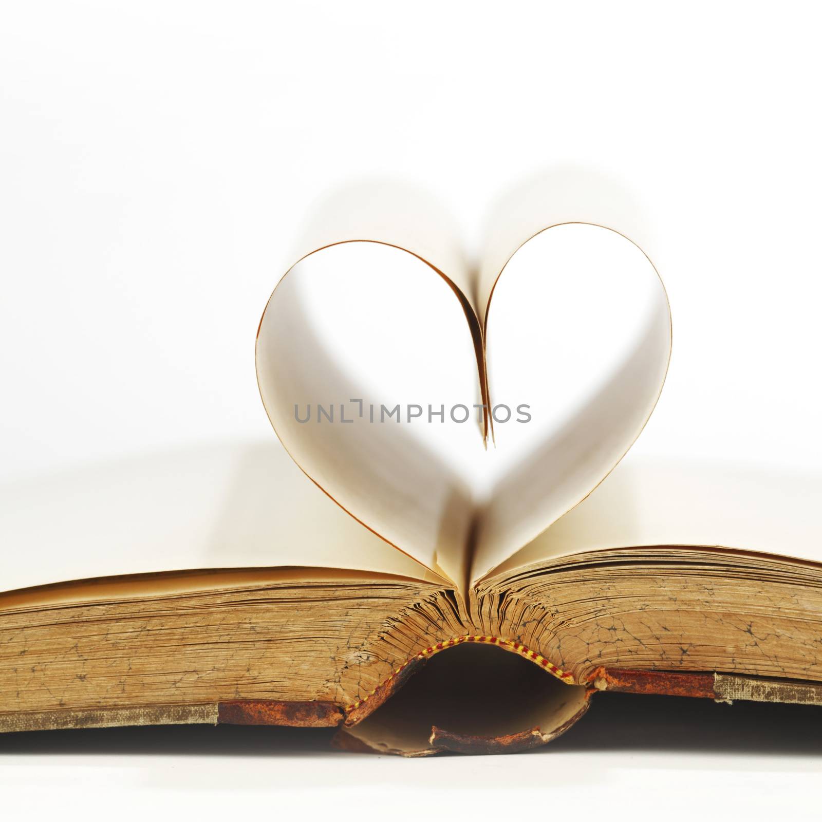 Heart made of blank pages inside a book on white background