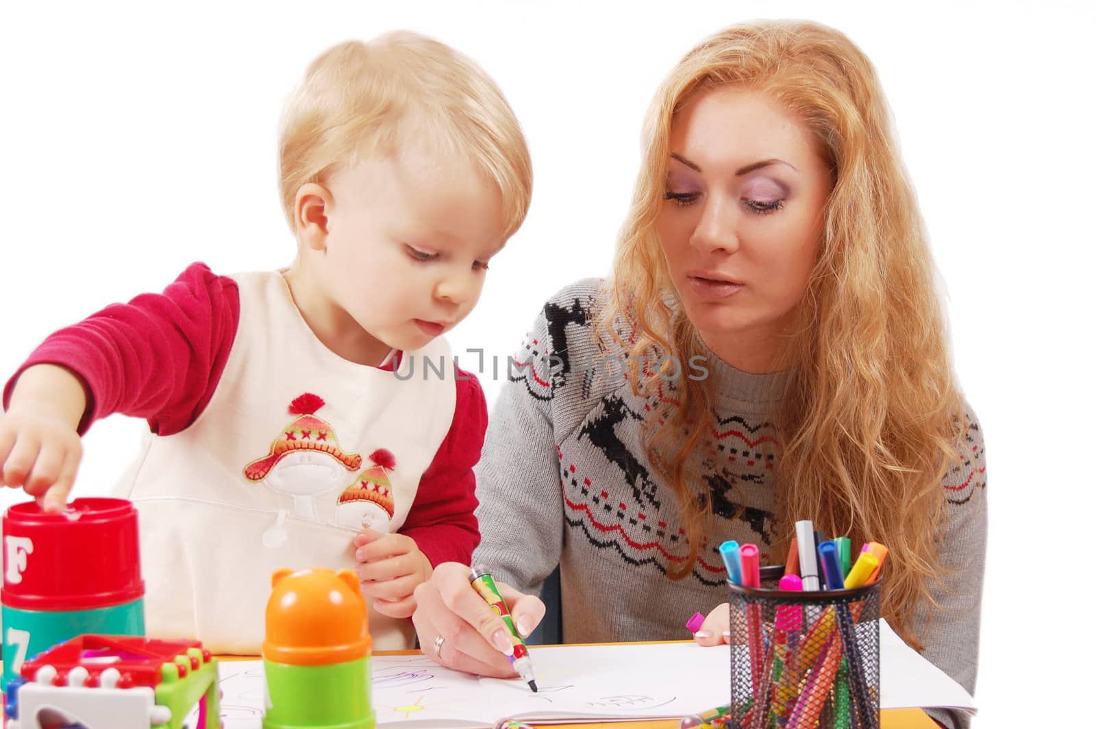 Little daughter learning to draw with her mother over white