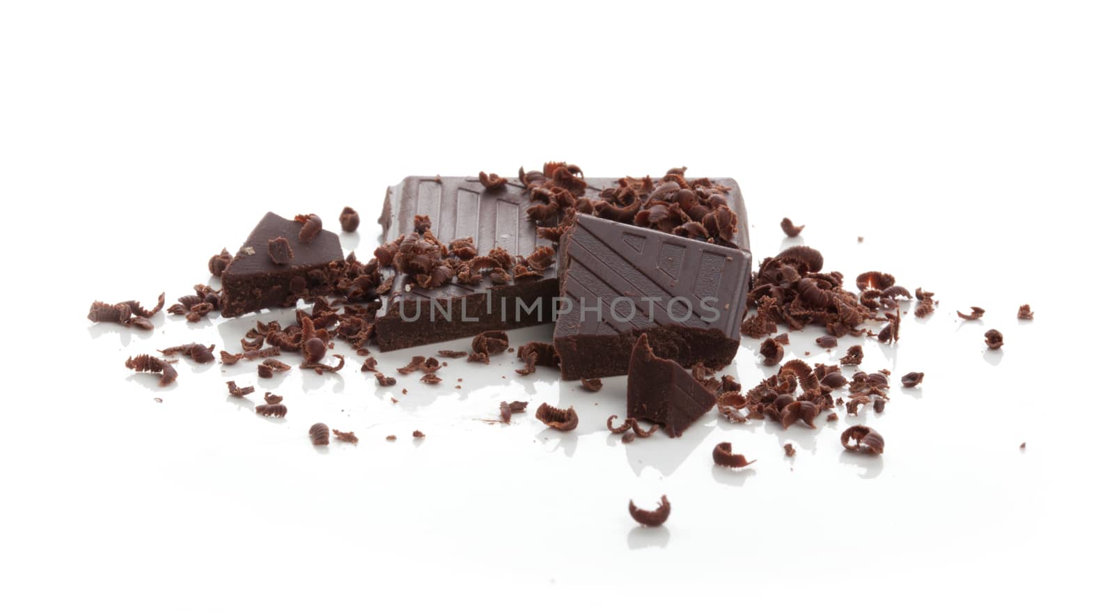 Pieces of chocolate bar with crumbs and cjips on the white background