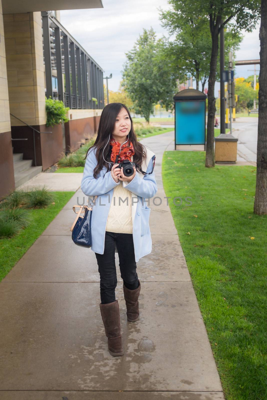 Girl with camer on public side walk by IVYPHOTOS