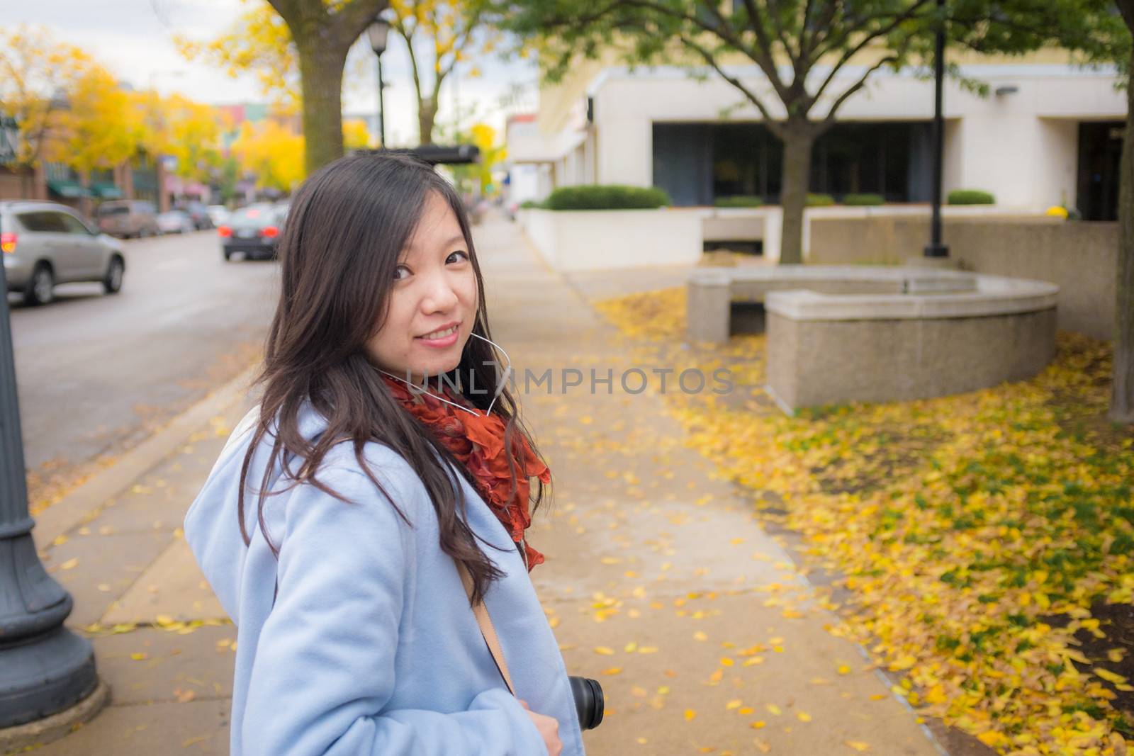 Girl with camer on public side walk by IVYPHOTOS