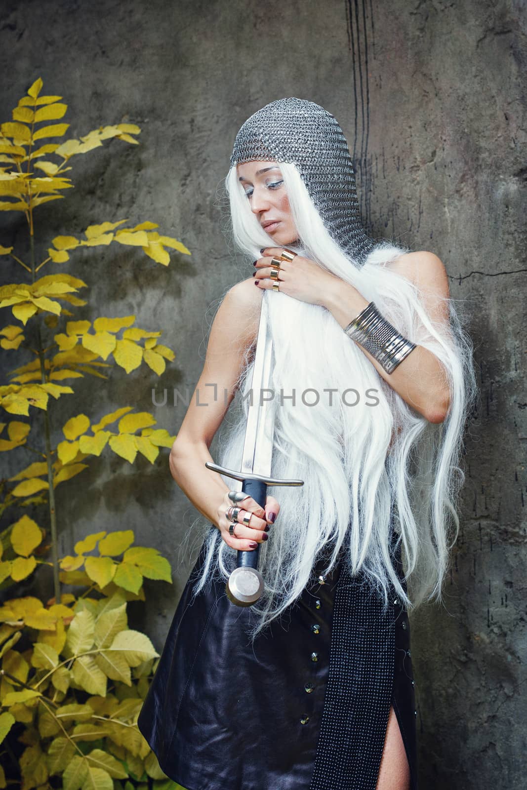 Attractive gray-haired maiden warrior in armor with sword in hand