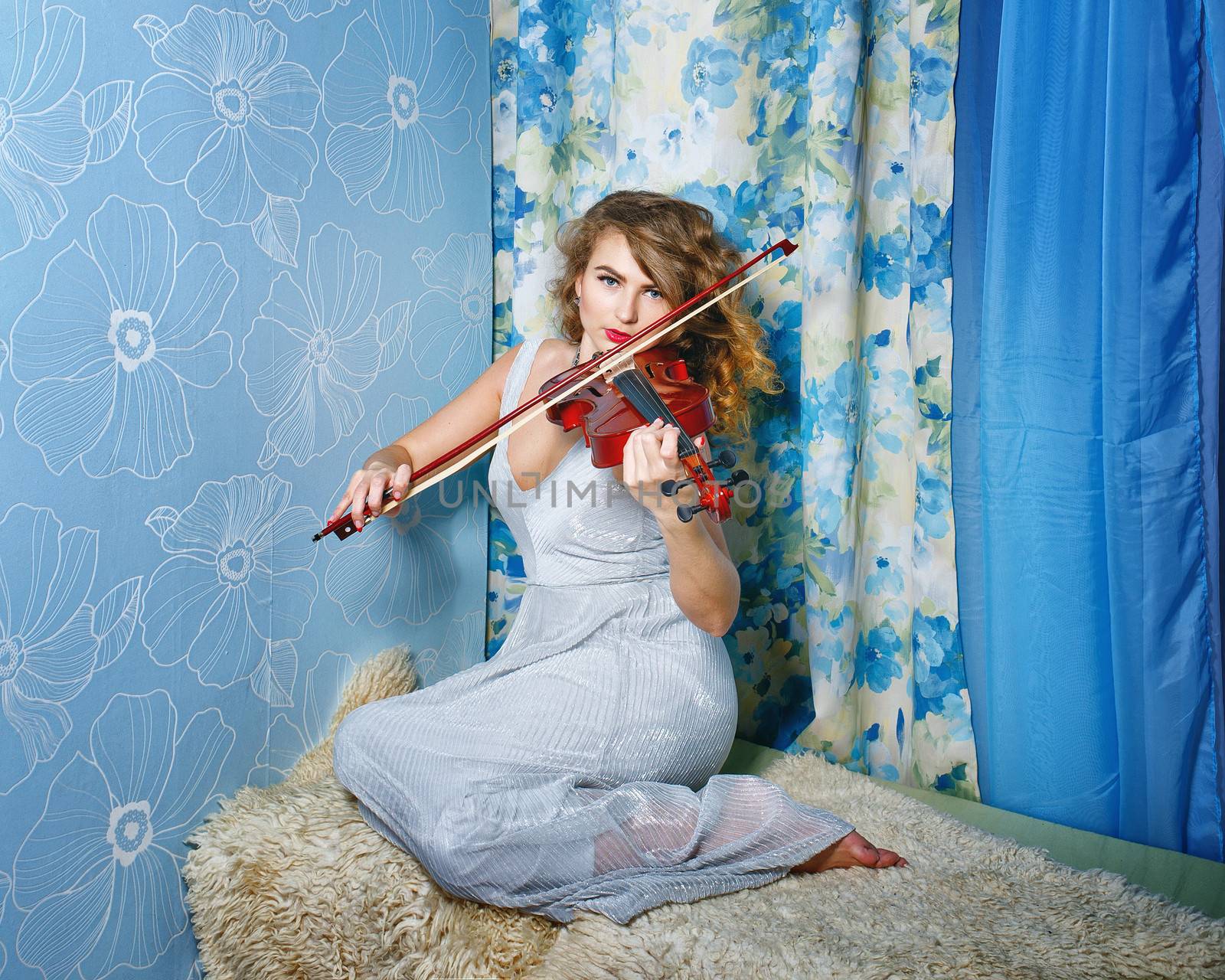 Attractive young woman holding violin in her hands