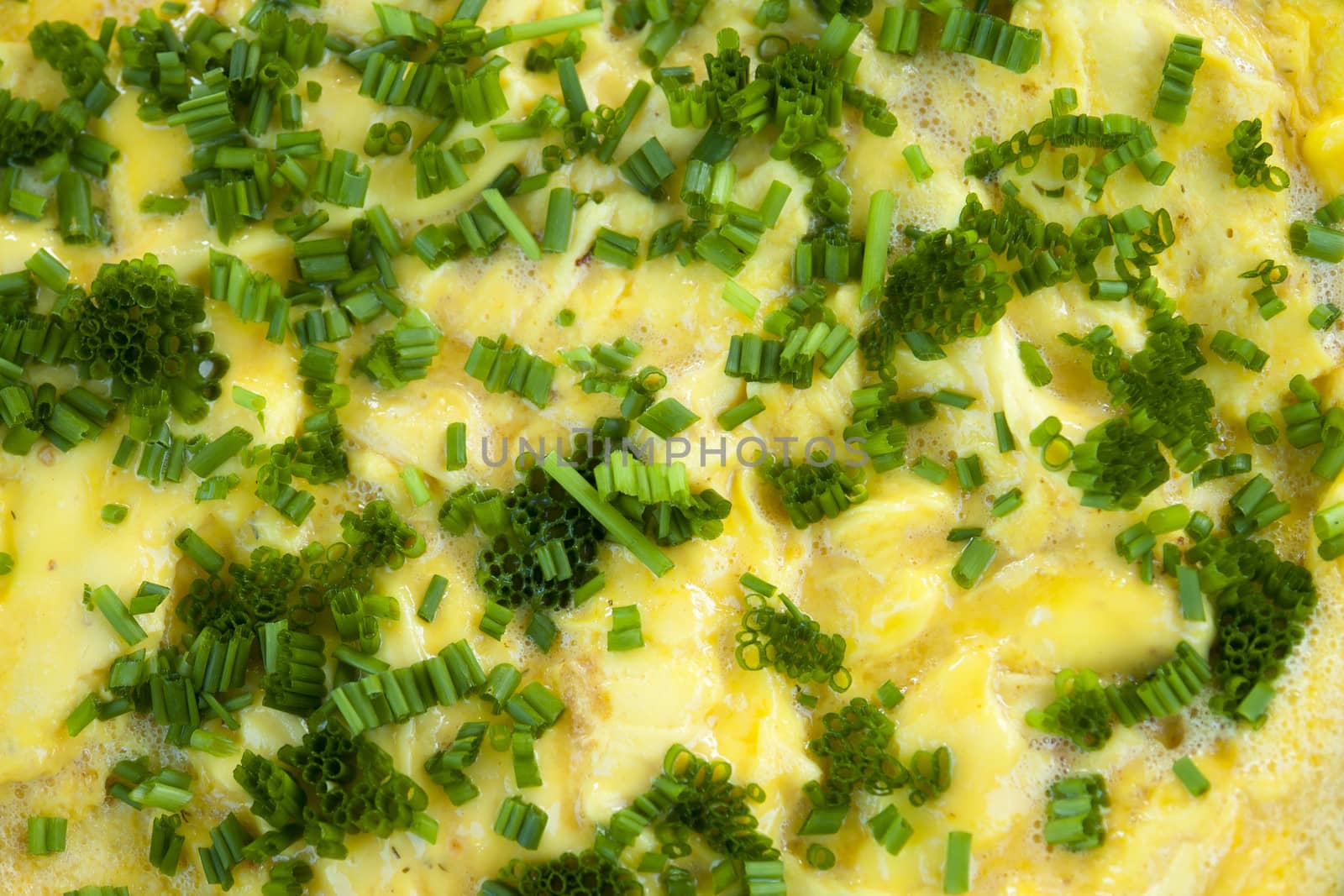Omelet scrambled eggs with chives and herbs in a close up view