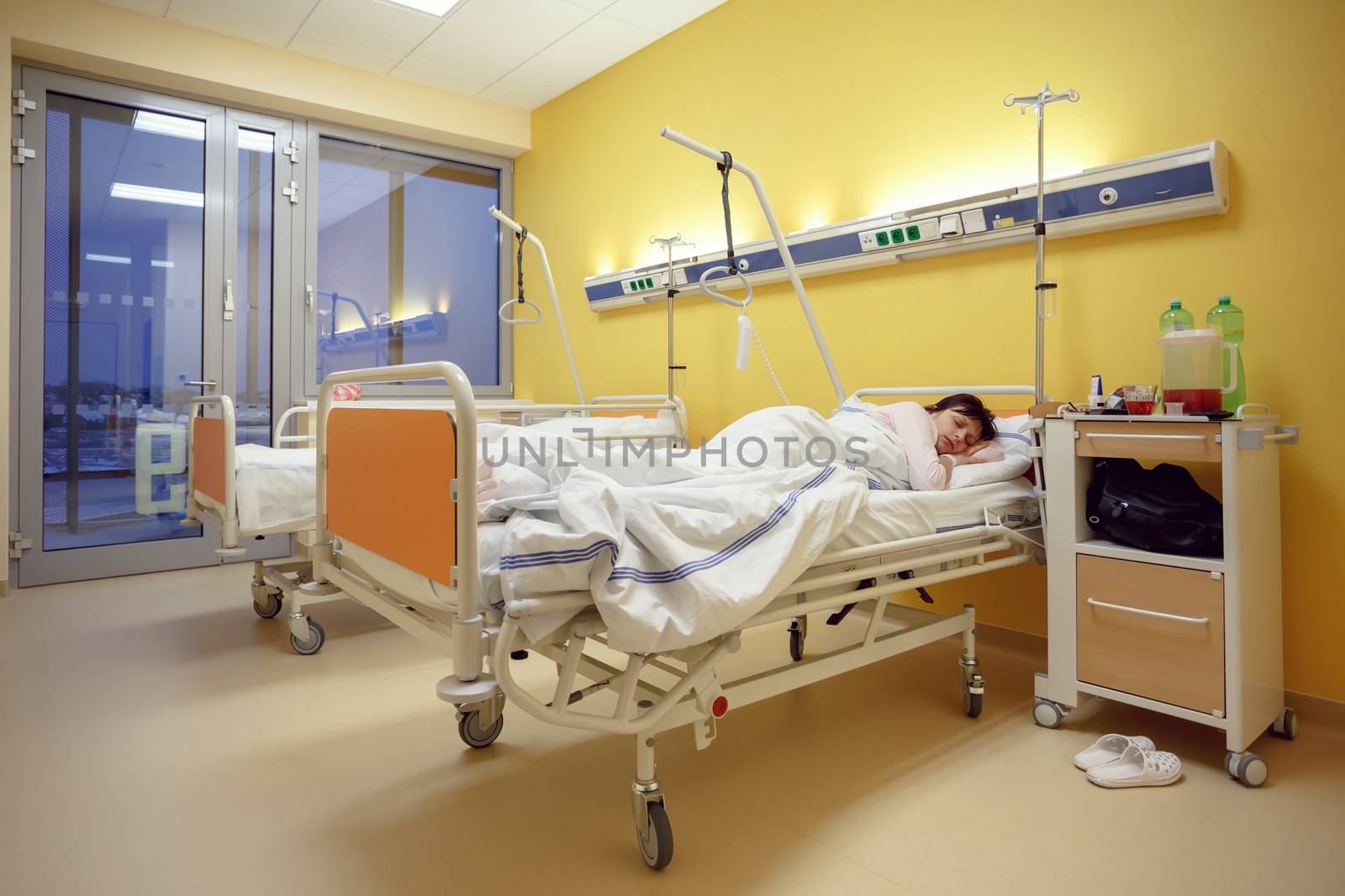 Real people in real situation, sad middle-aged woman lying in hospital with pneumonia
