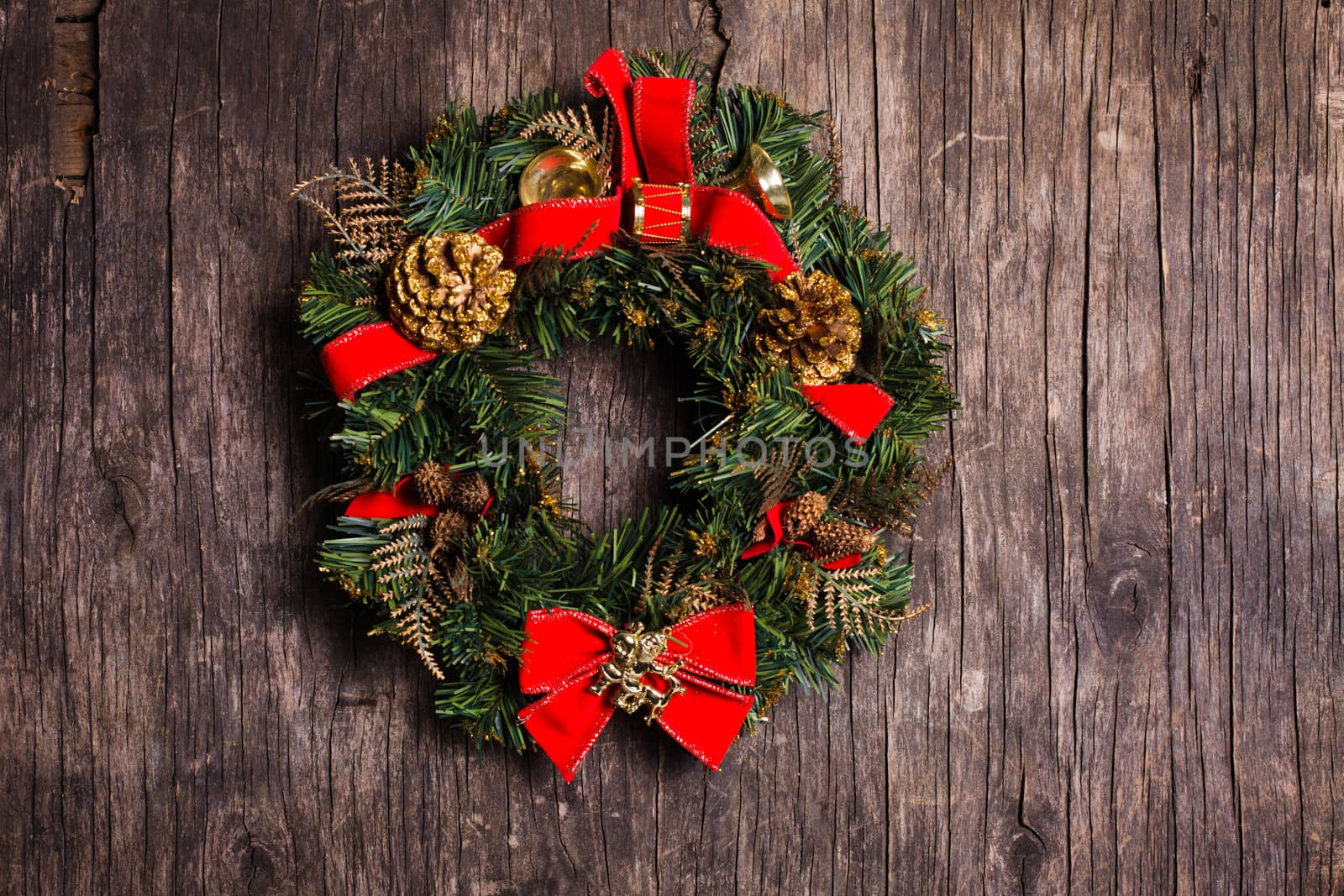 Christmas wreath with decorations on the rustic wooden background