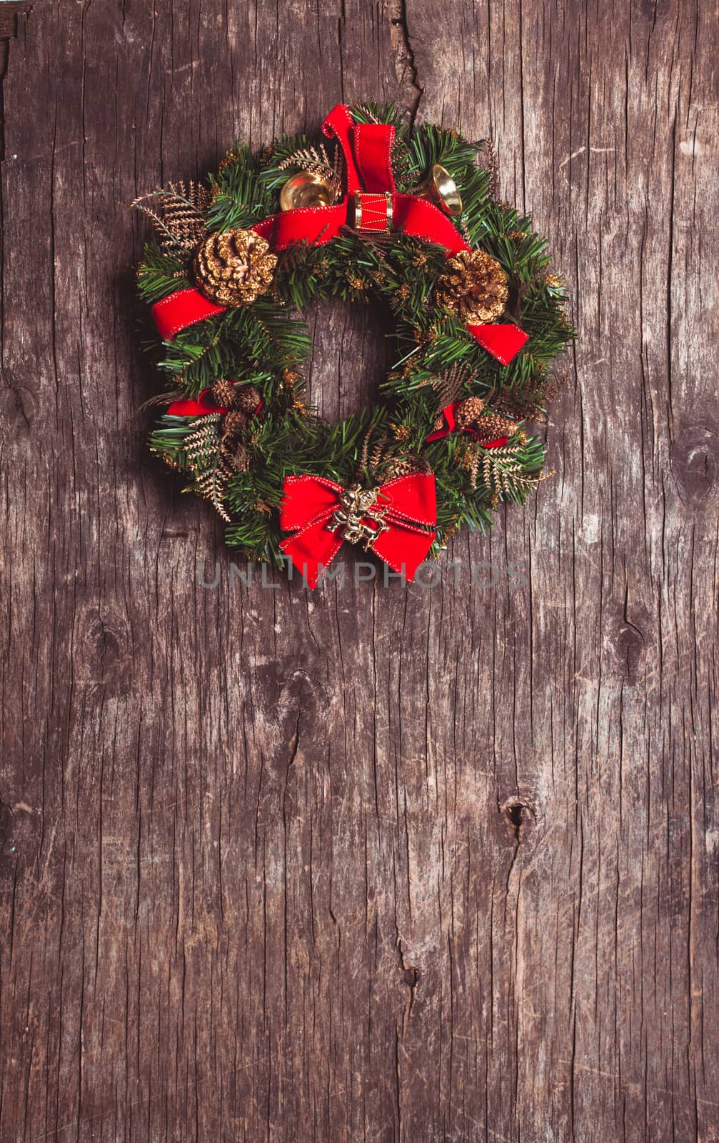 Christmas wreath with decorations on the rustic wooden background