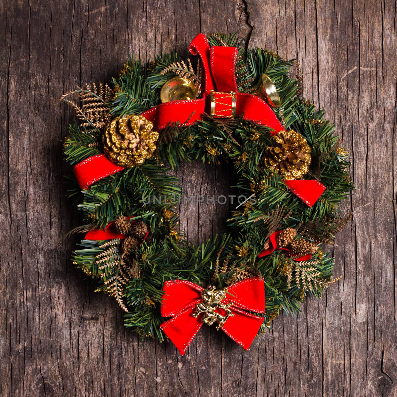 Christmas wreath with decorations on the rustic wooden background