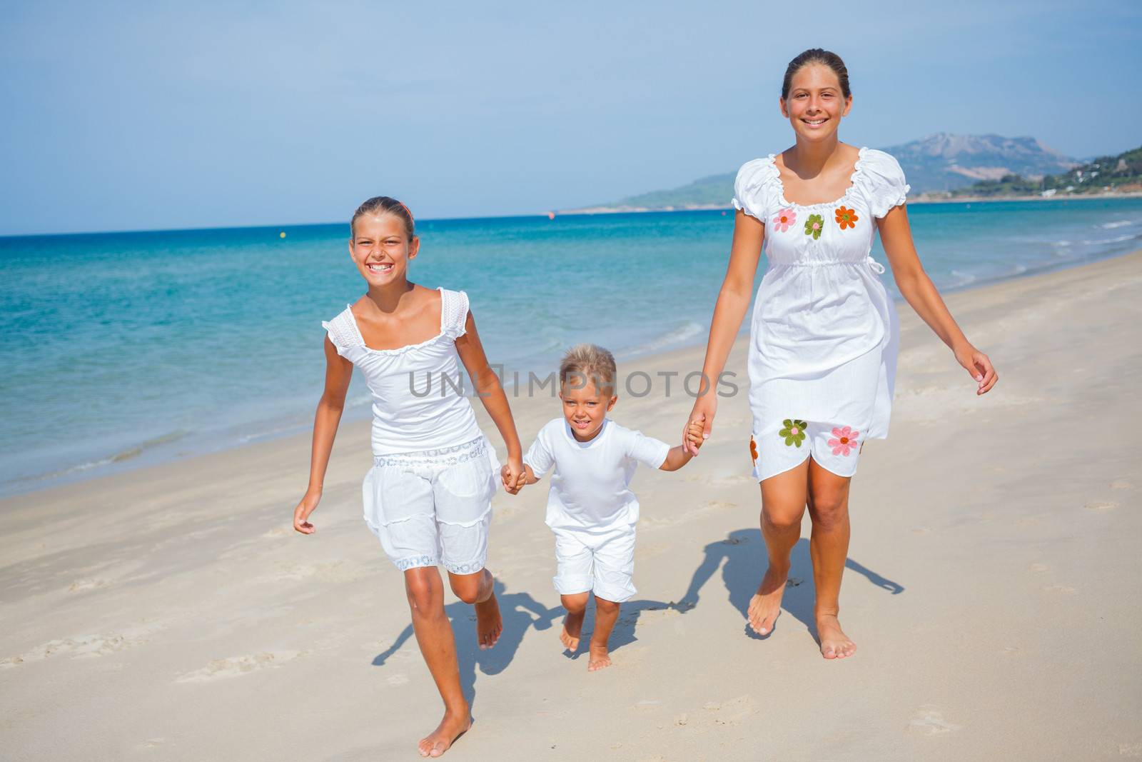 Adorable happy boy and girls running on beach vacation