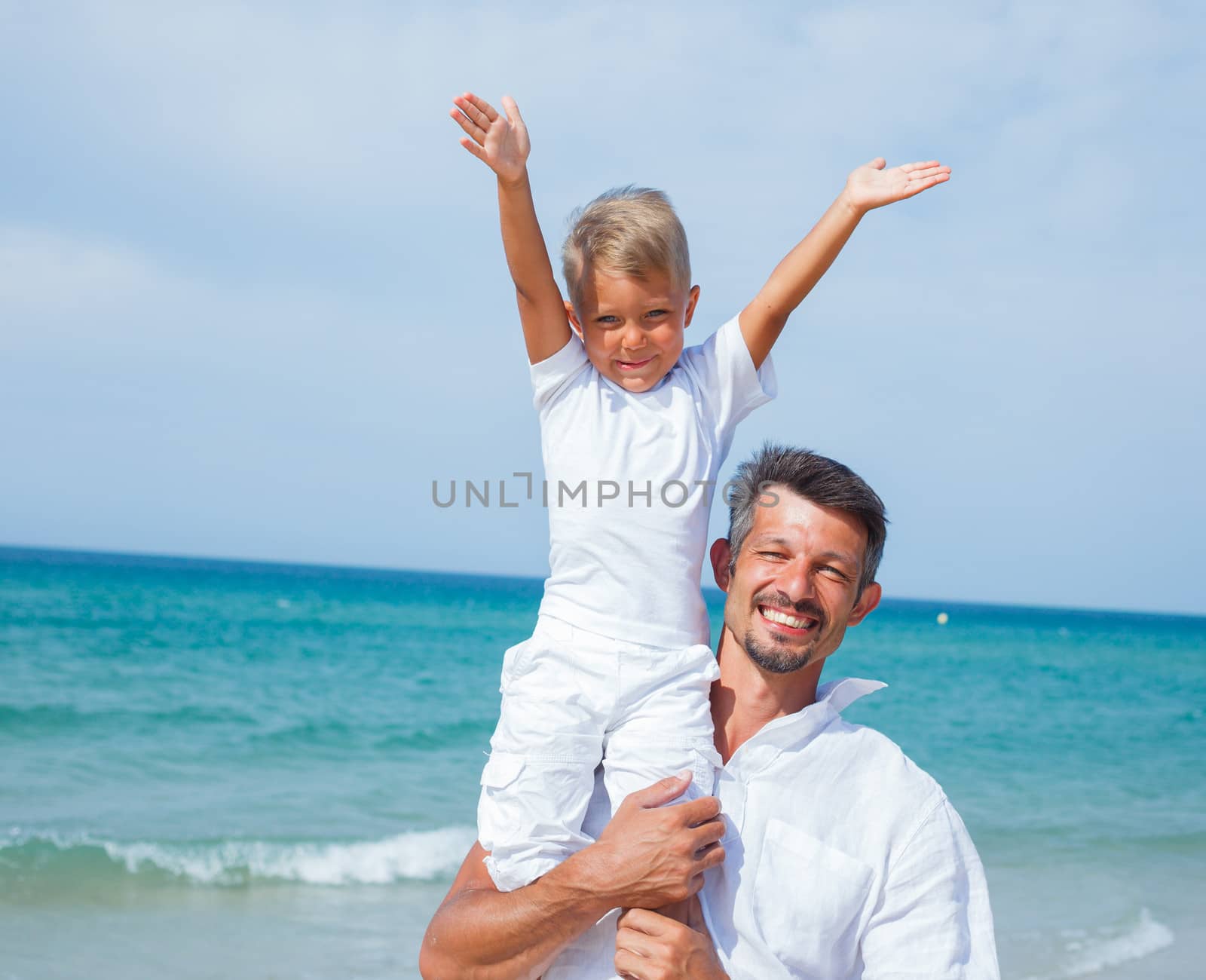 Father and son having fun on tropical beach
