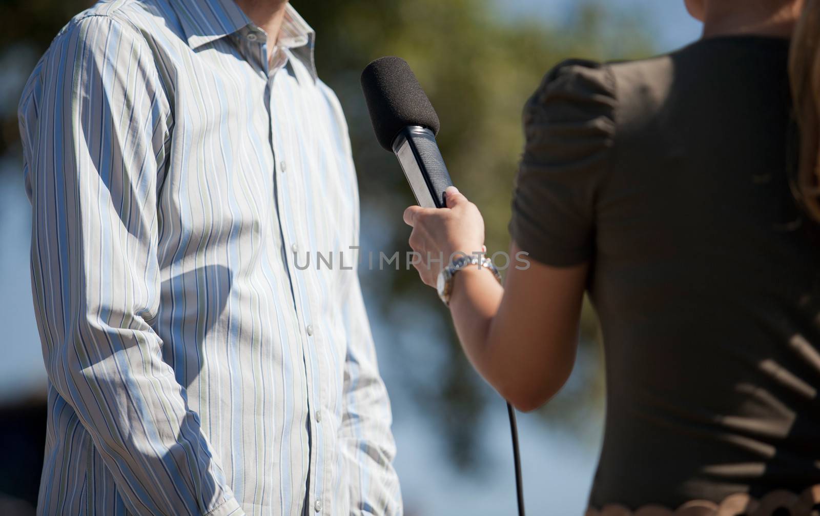 A journalist is making a interview with a microphone