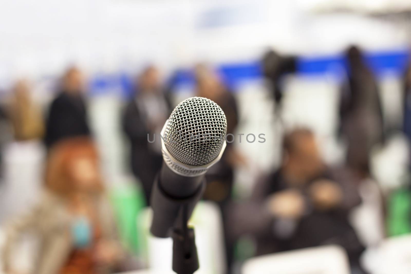 Microphone in focus against blurred audience